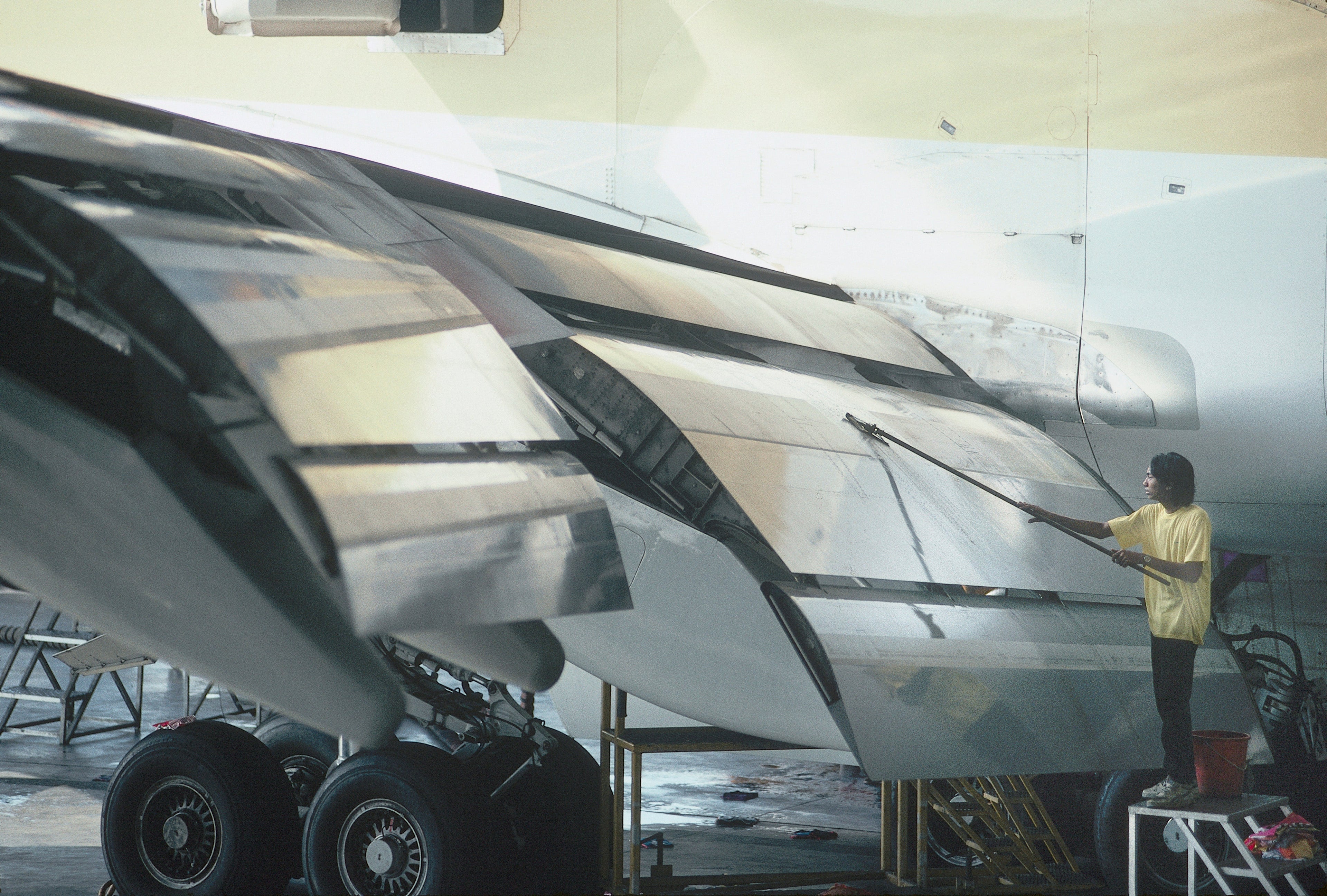 worker adjusting plane wing