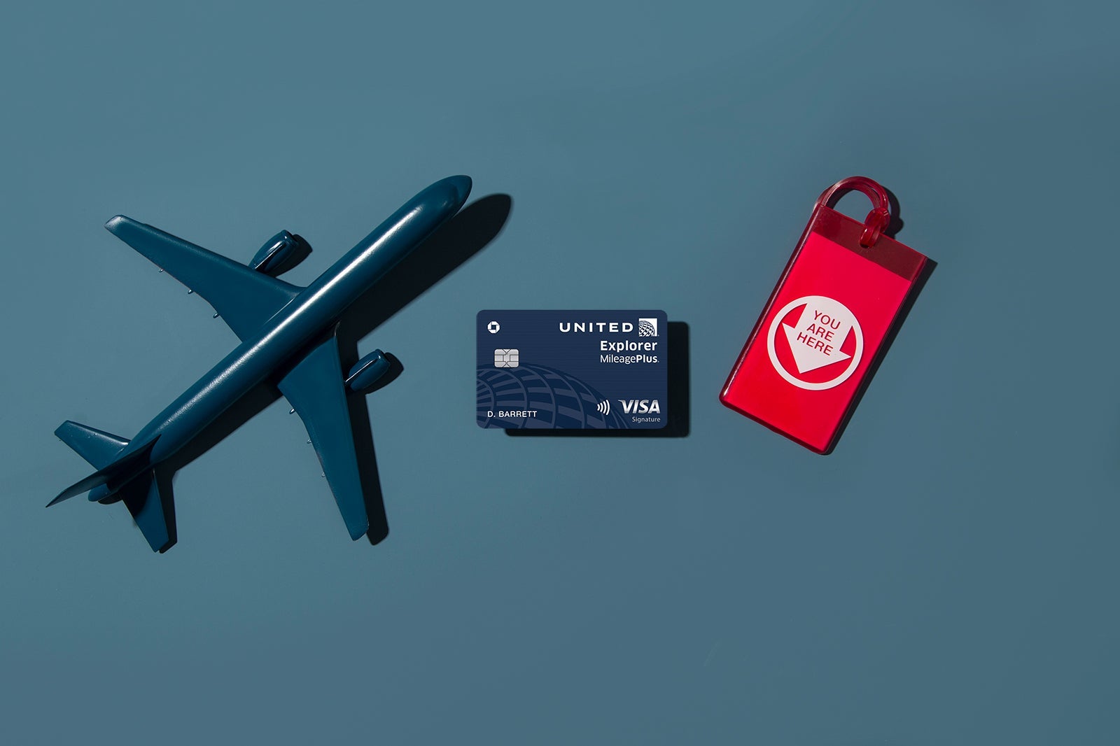 a credit card between a model plane and travel cup