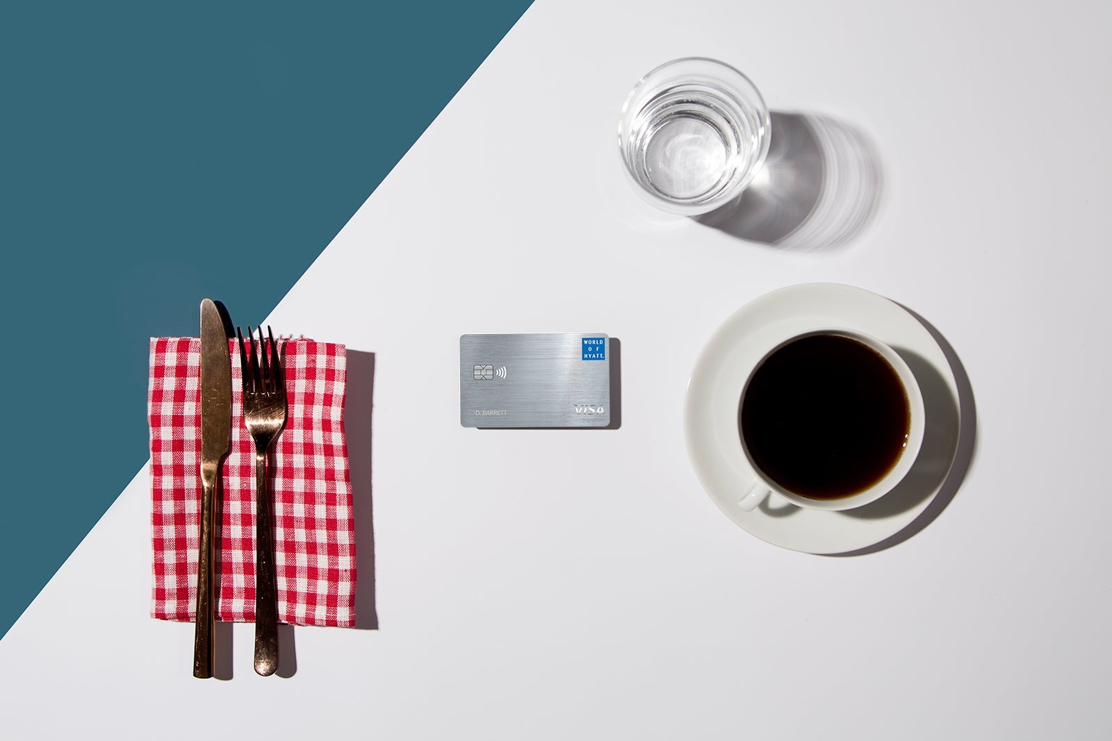 a credit card between silverware and a coffee mug