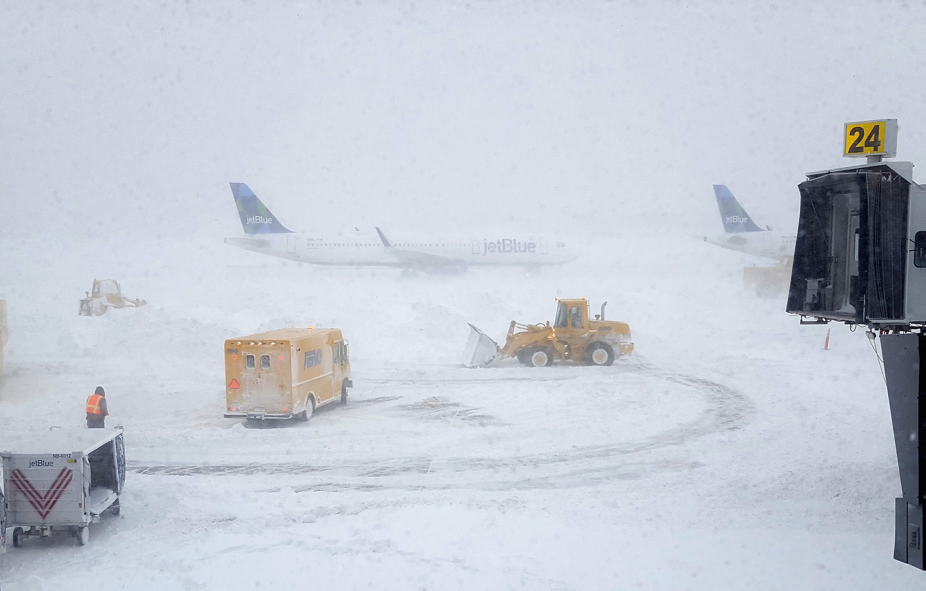 NEW YORK, NY - JANUARY 04: Snow plows move snow as a JetBlue airplane waits outside terminal five at John F. Kennedy International Airport on January 4, 2018 in the Queens borough of New York City. A winter storm is traveling up the east coast of the United States dumping snow and creating blizzard like conditions in many areas. (Photo by Rebecca Butala How/Getty Images)