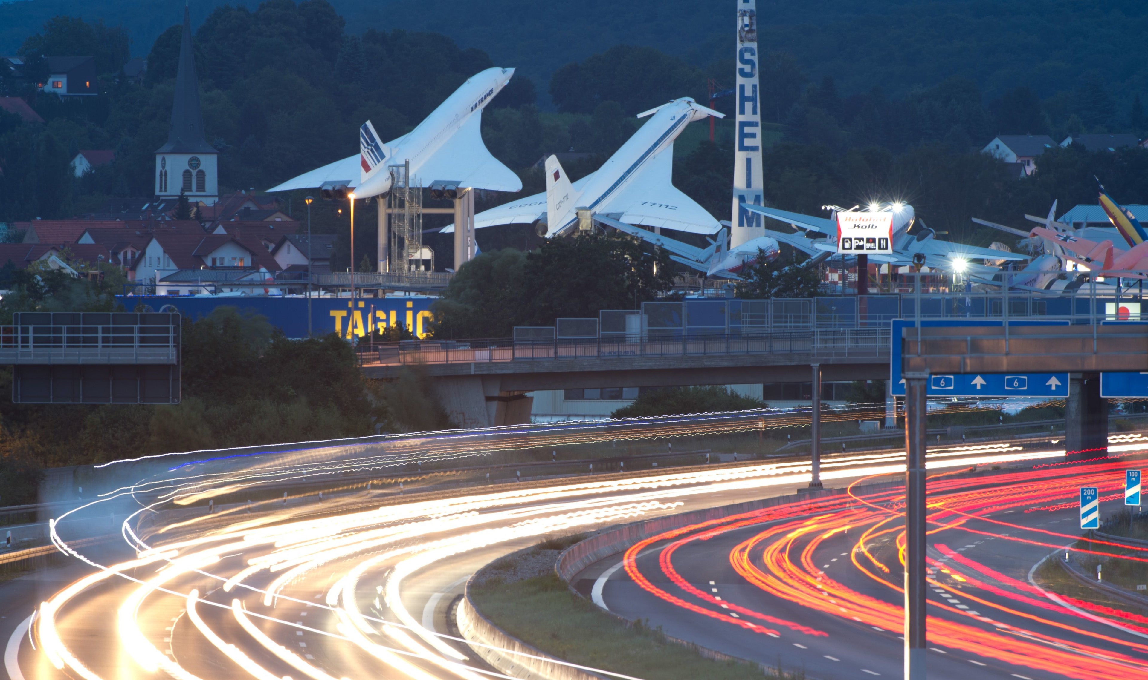 Cars drive along motorway A6 past a supersonic passenger airliner Concorde (L) and a Tupolev TU-144 and leave streaks of light in Sinsheim, Germany, 06 August 2014 (TIME EXPOSURE). The two airplanes ar epart of the exhibition at Automotive and Technical Museum in Sinsheim. Photo: SEBASTIAN KAHNERT/DPA | usage worldwide (Photo by Sebastian Kahnert/picture alliance via Getty Images)