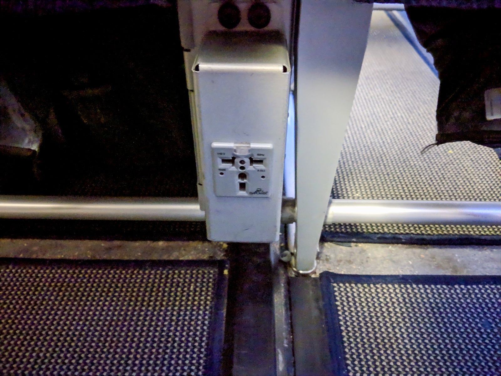 A power outlet is located between each pair of seats.