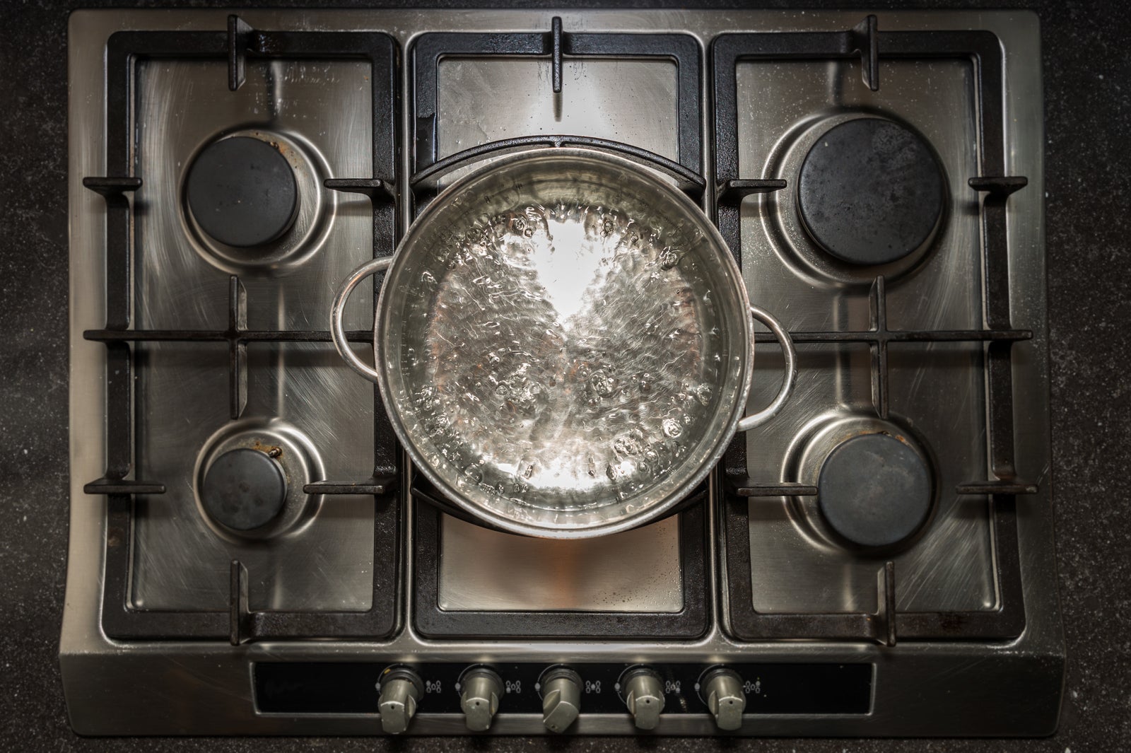 Metal cooking pan with boiling water and on a cooker, stove