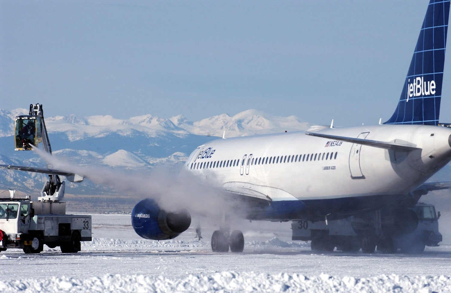 DENVER - DECEMBER 22: De-Icing crews remove snow and ice from a plane that has been grounded due to a recent blizzard at Denver International Airport December 22, 2006 in Denver, Colorado. On Friday the clean-up began after the storm left thousands of travelers stranded and also caused a shut down of the city and highways exiting Denver.. (Photo by Thomas Cooper/Getty Images)