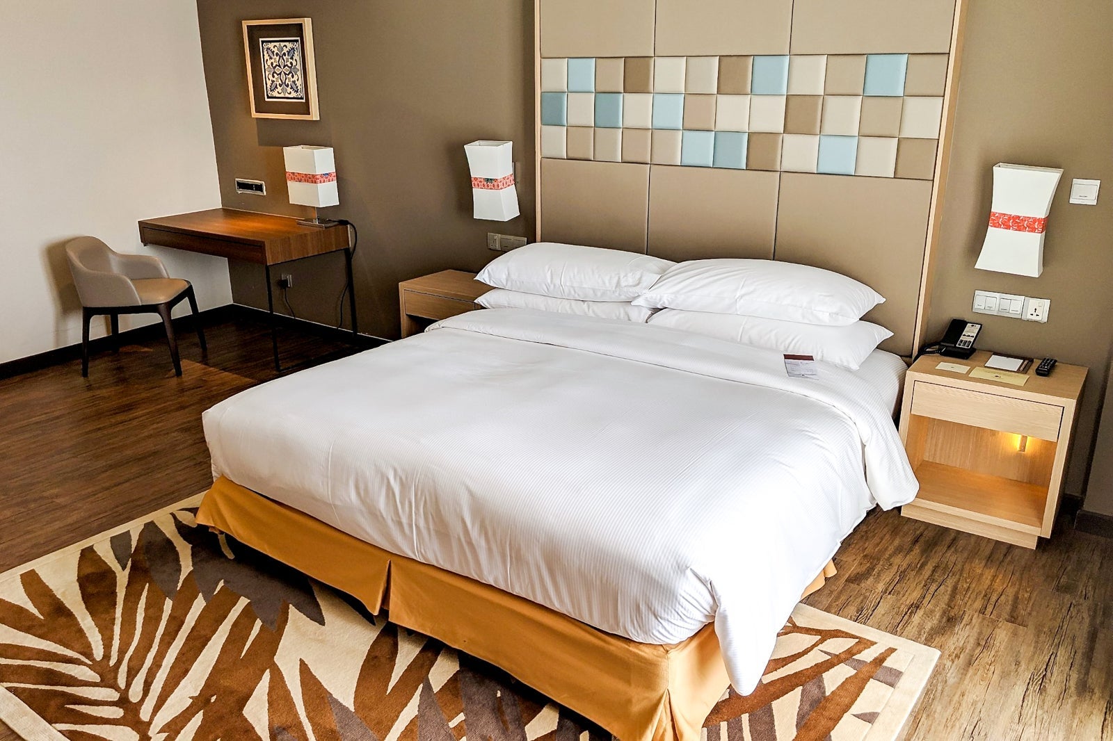 a hotel room with tan, beige and brown tones in its decorations