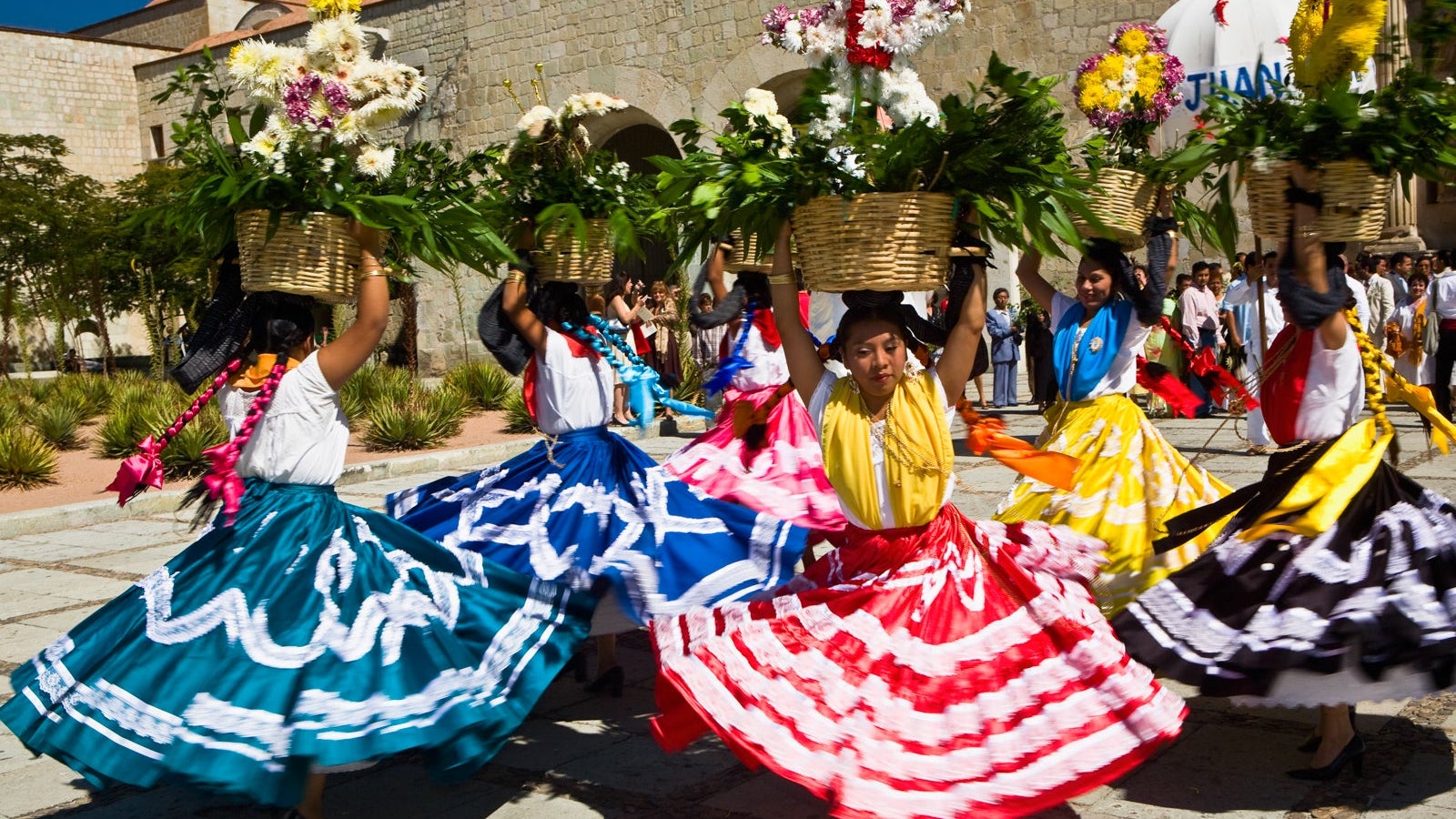 Female dancers dancing with potted plant over their head, Oaxaca, Oxaca State, Mexico