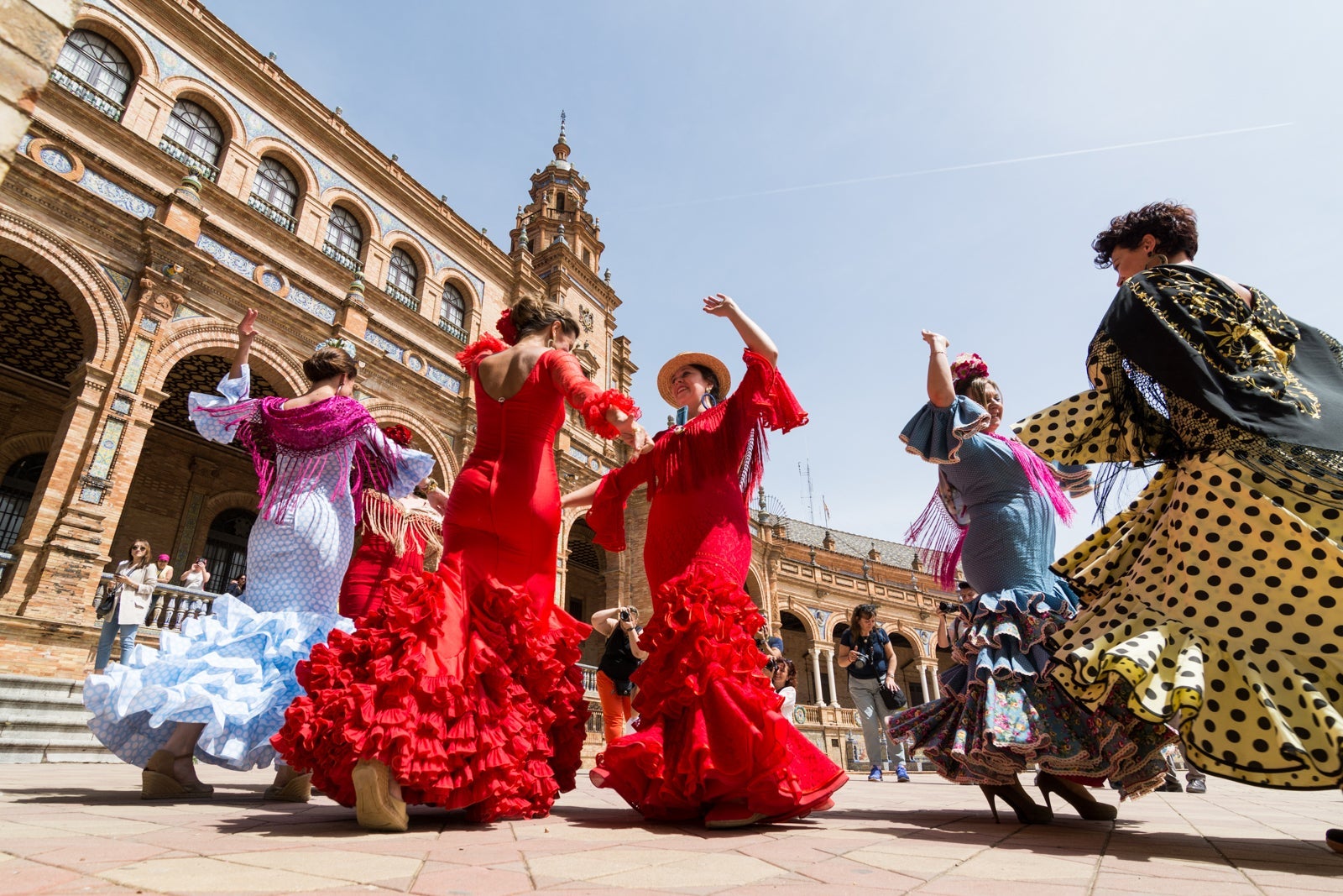 Women dancing flamenco on Plaza de Espana during Seville's Feria Festival. (Photo by leonovo / Getty Images)