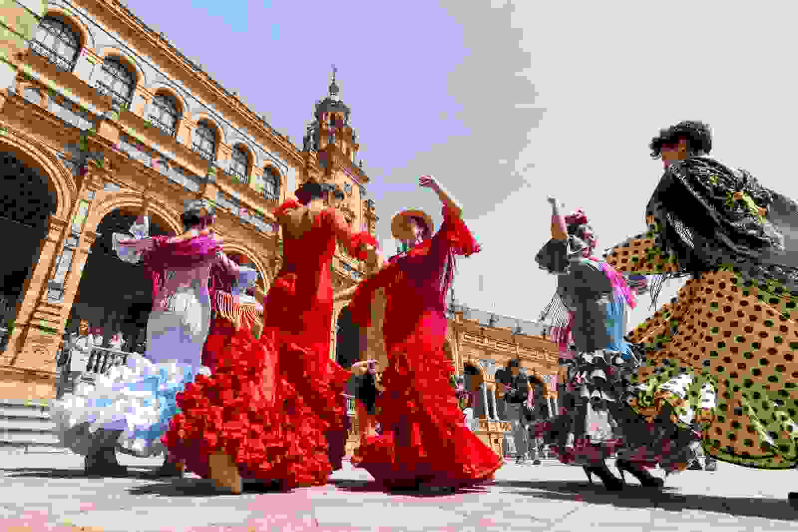 Women dancing flamenco on Plaza de Espana during Seville's Feria Festival. (Photo by leonovo / Getty Images)