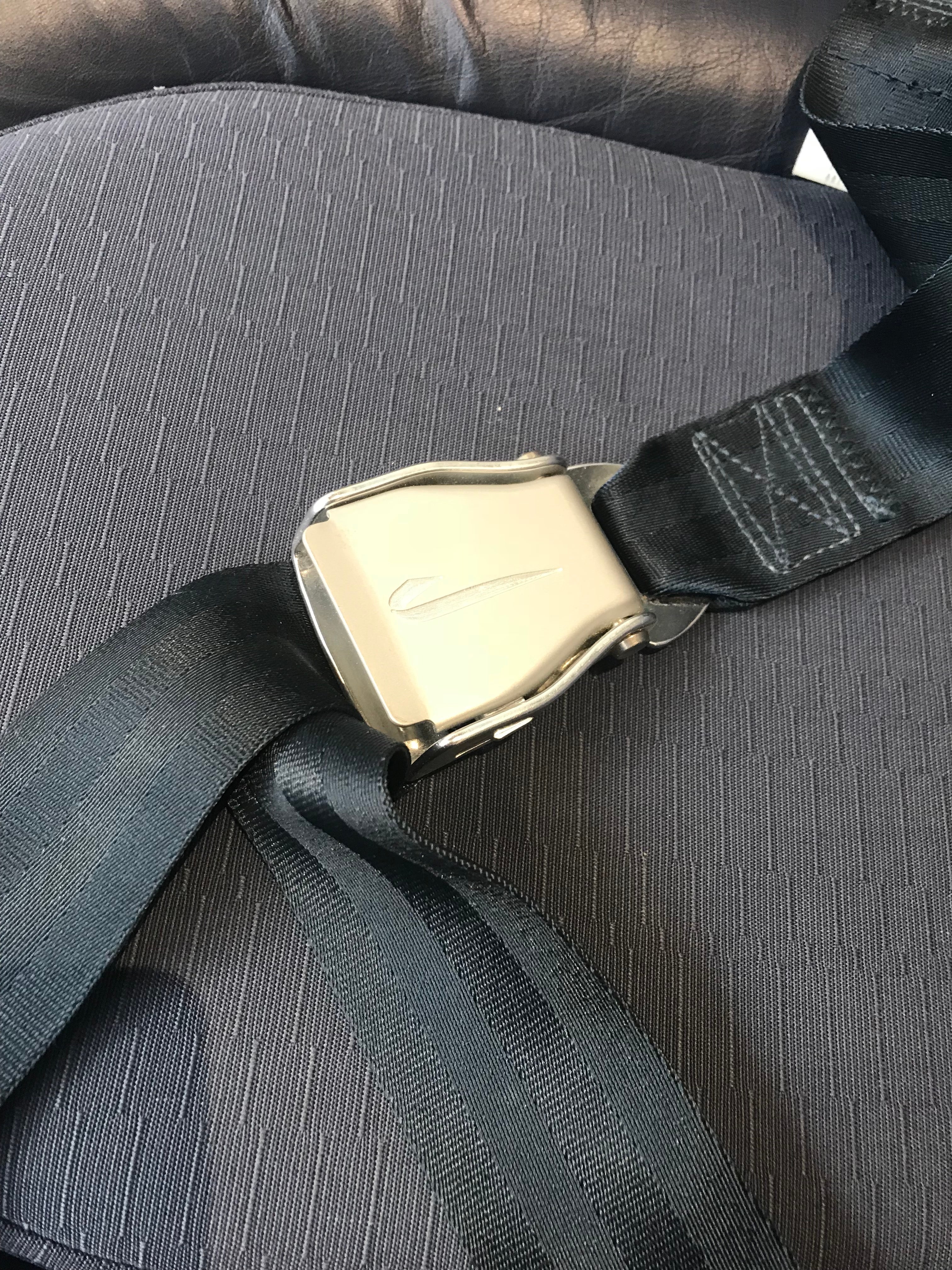 Custom-branded, brushed aluminum British Airways seat belts on the last interior design of Concorde. Image by author.