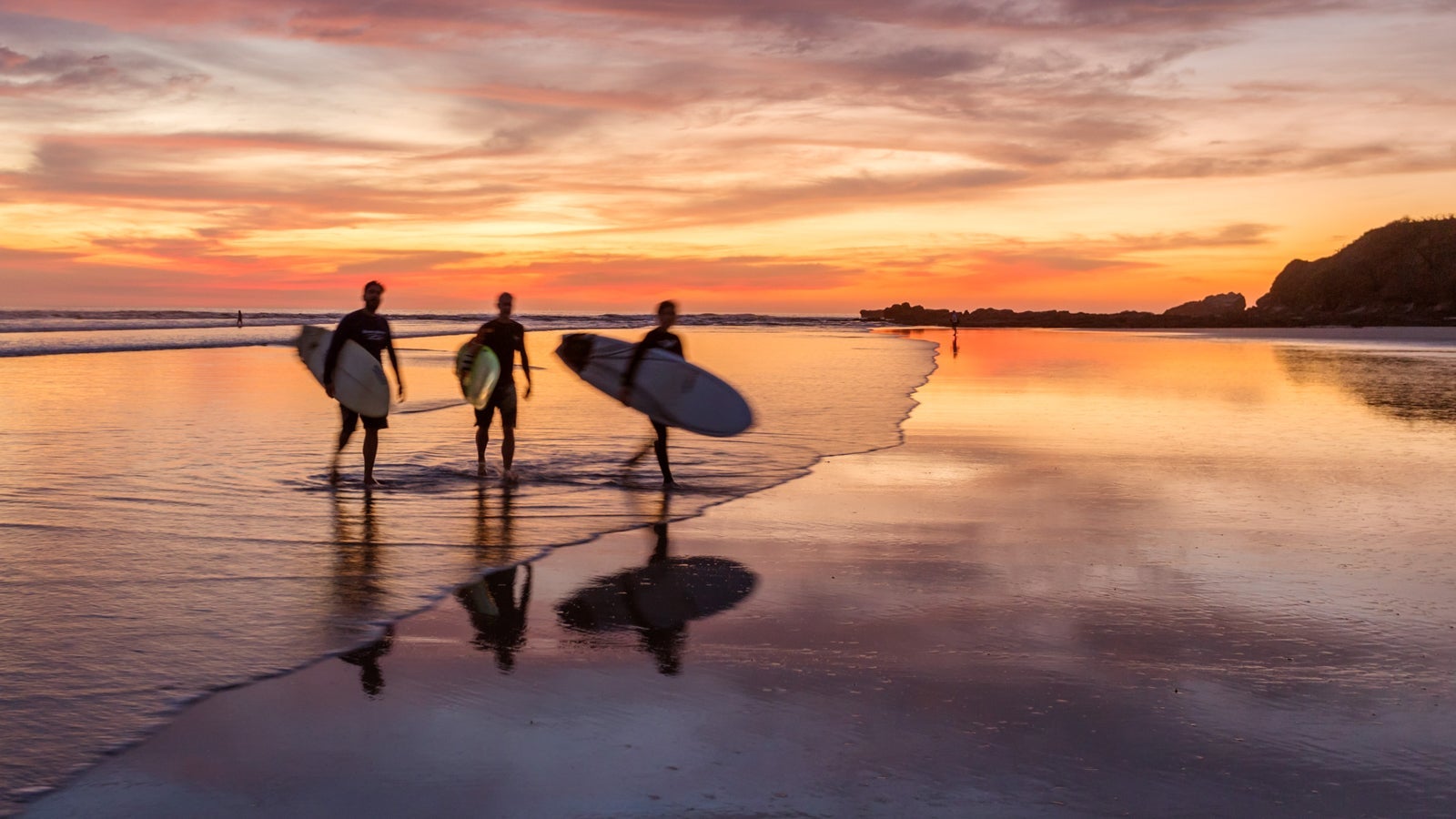 Surfers at sunset in Guanacaste, Costa Rica