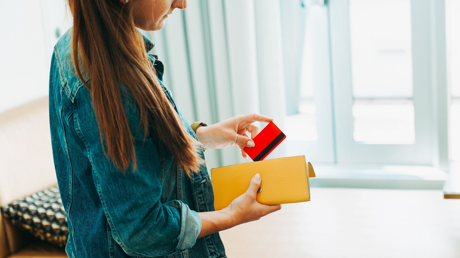 A woman taking a credit card out of her wallet