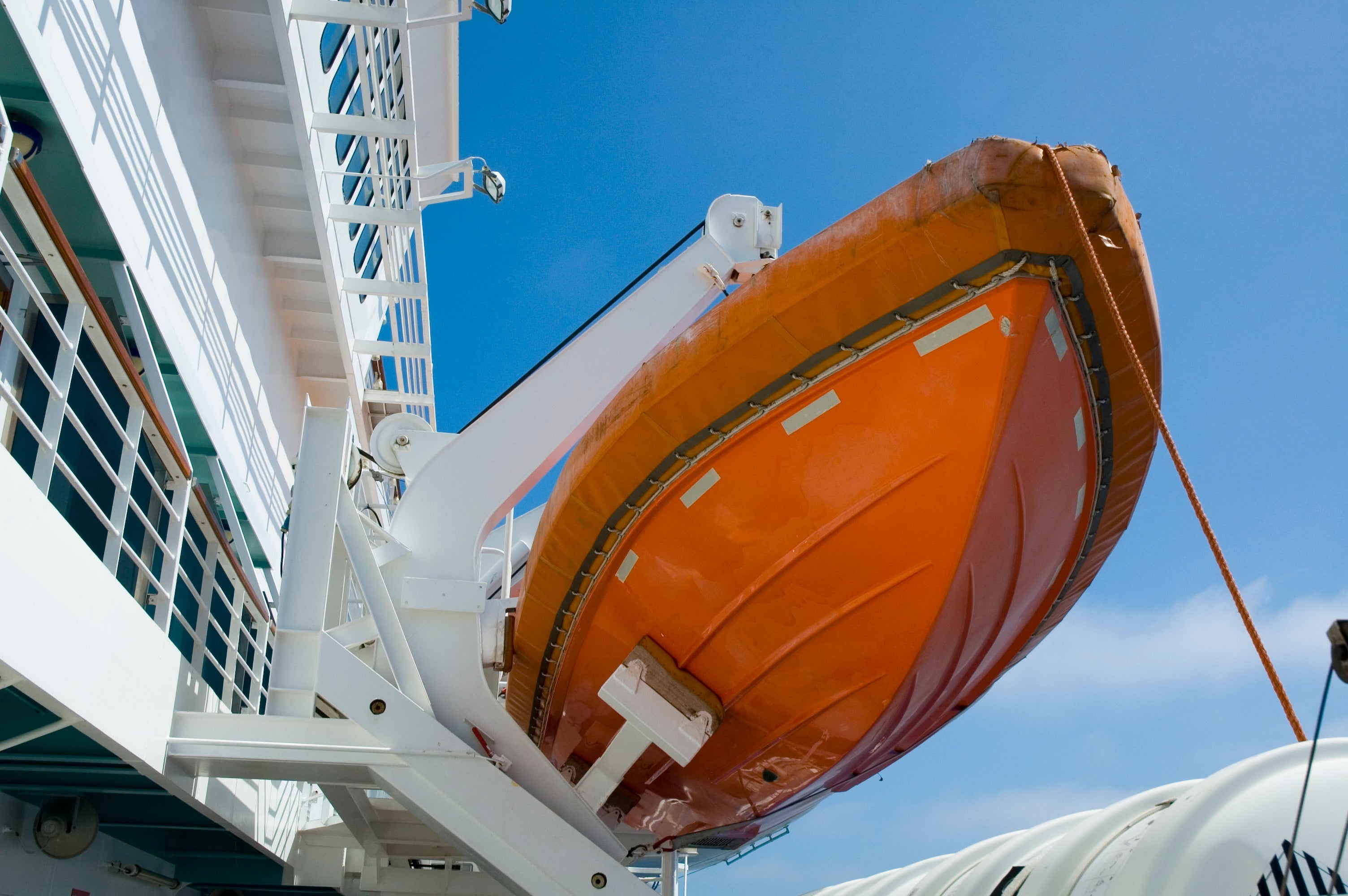 A life boat hanging from the side of a cruise ship