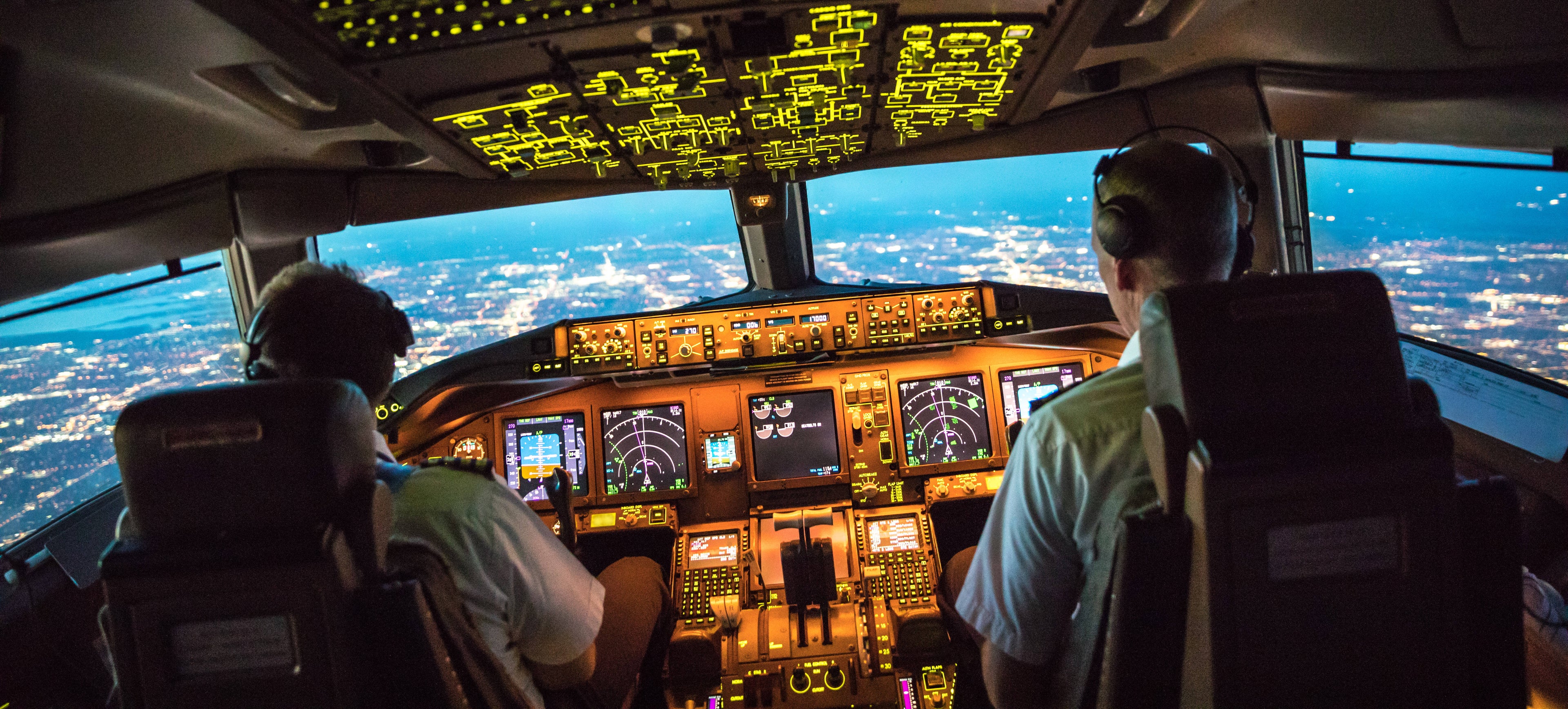 Two pilots at work during departure of Dallas Fort Worth Airport in United States of America. The view from the flight deck with high workload the beginning night through the wind shield
