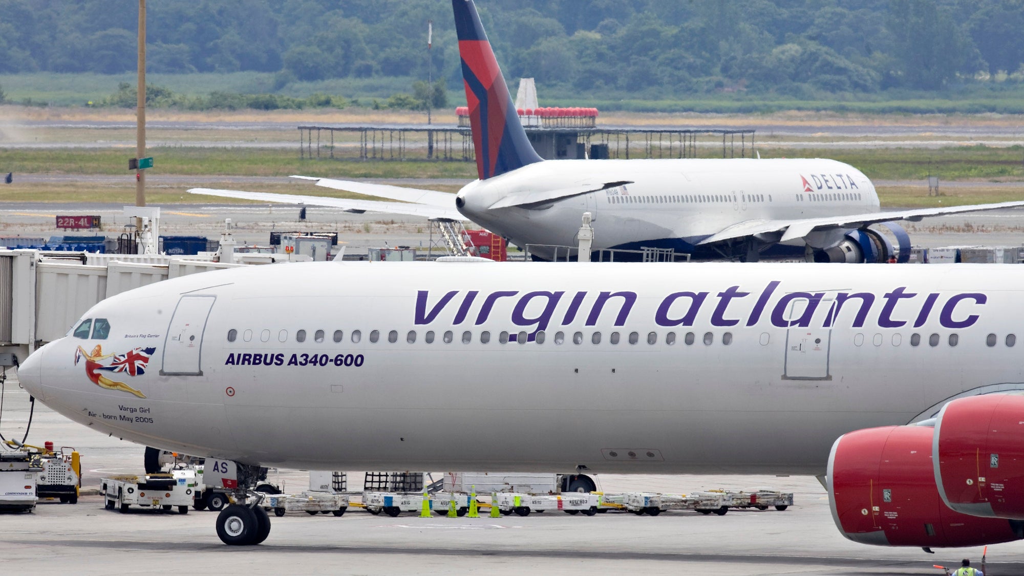 A Virgin Atlantic plane taxis past a Delta plane at John F.