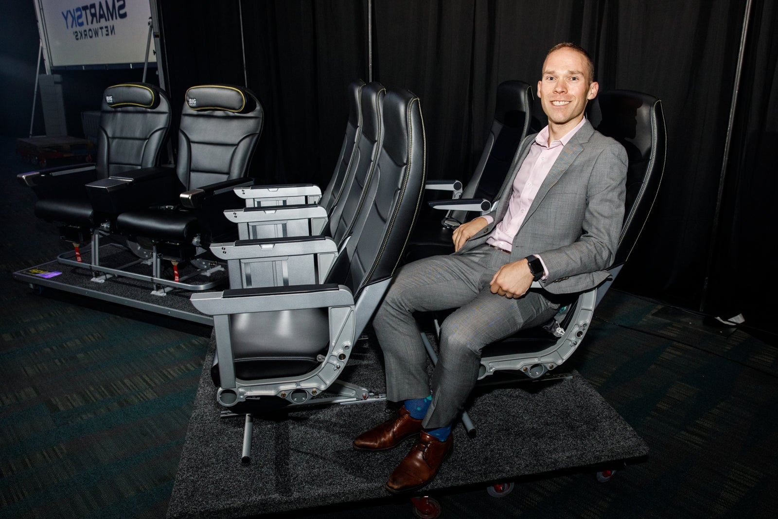 TPG reporter Edward Russell shows off the personal space for Spirit Airlines' new seats that the carrier unveiled in a demo in Los Angeles on Sept. 9, 2019. (Photo by Patrick Fallon/The Points Guy)