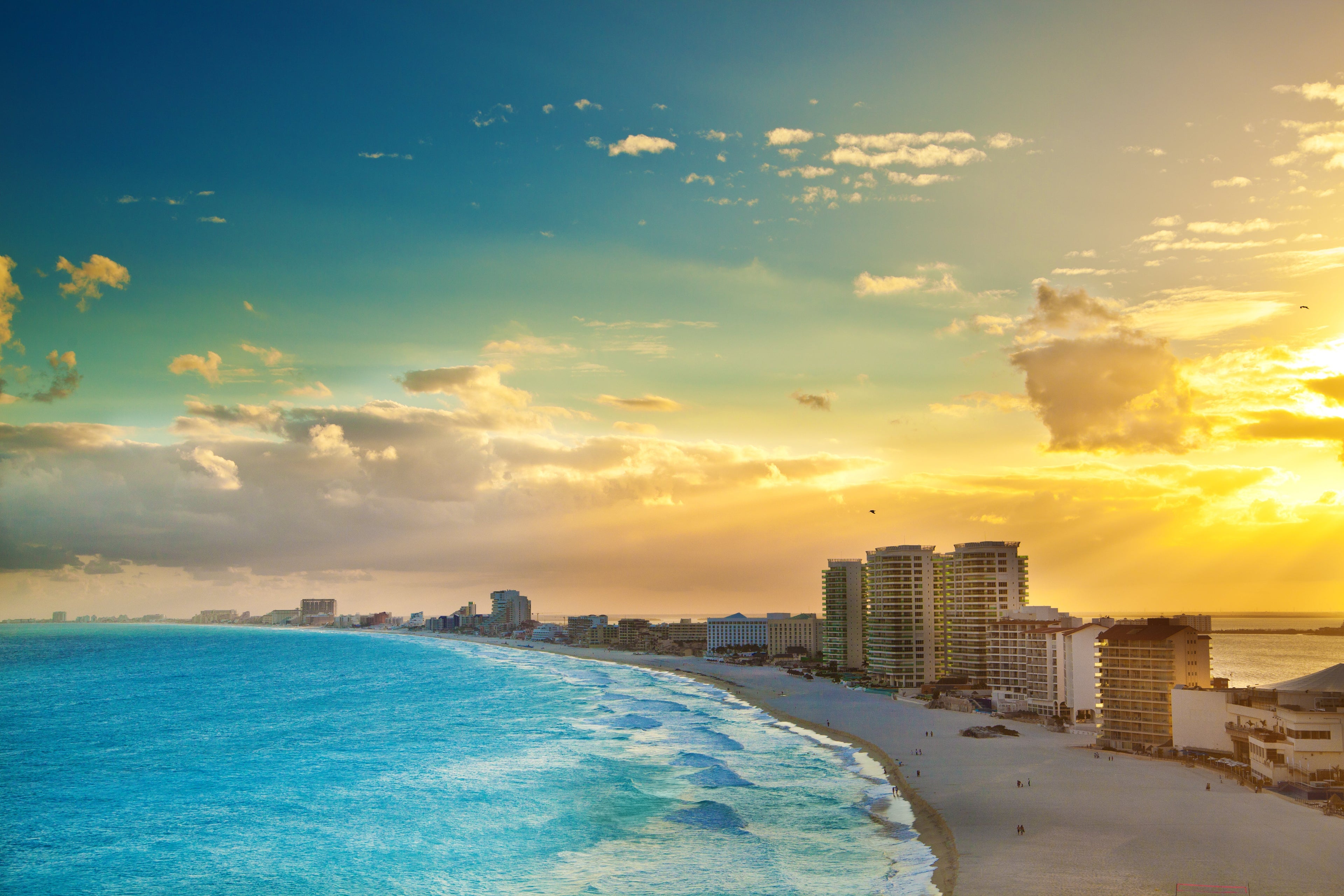 Subject: A panoramic view of the hotel district of Cancun at sunset.