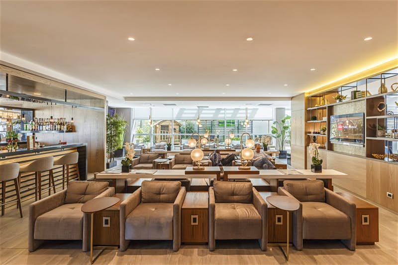 Seating and large windows with lots of natural light at an airport lounge