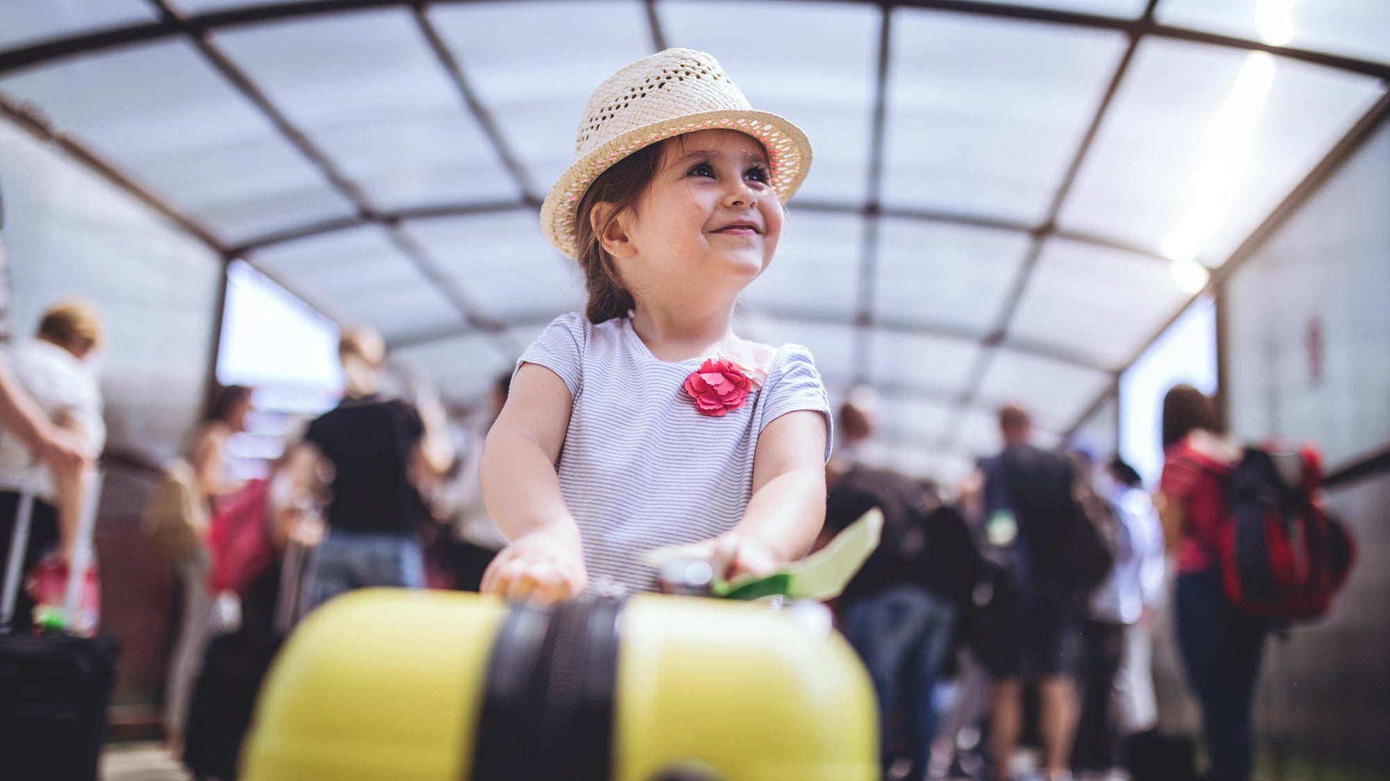 Cheerful and excited toddler with her coffer on a airport