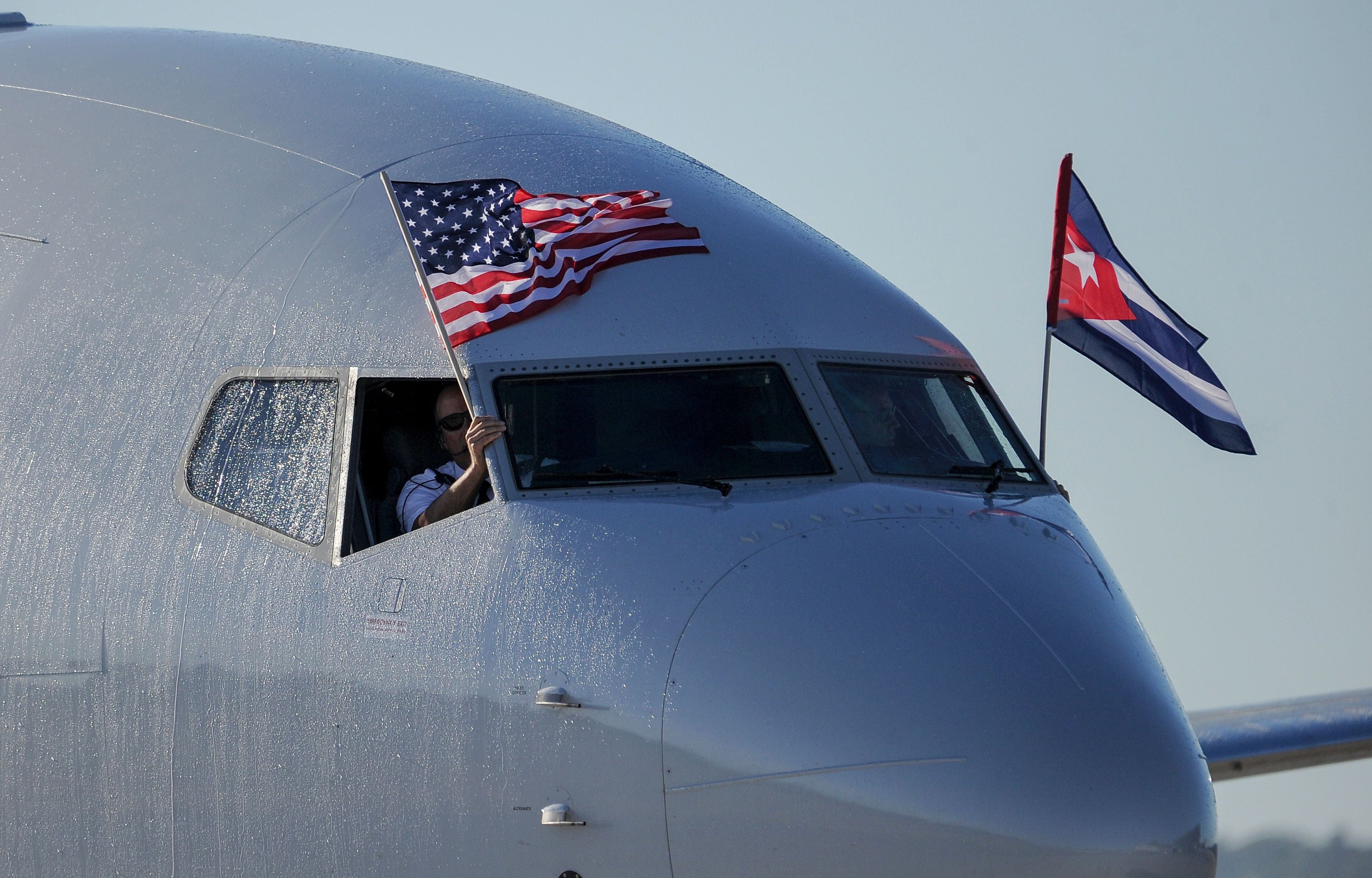 An American Airlines plane fluttering U.S. and Cuban flags is seen upon arrival at Jose Marti International Airport on Nov. 28, 2016, becoming the first Miami-Havana commercial flight in 50 years. (Photo by Yamil Lage/AFP via Getty Images)