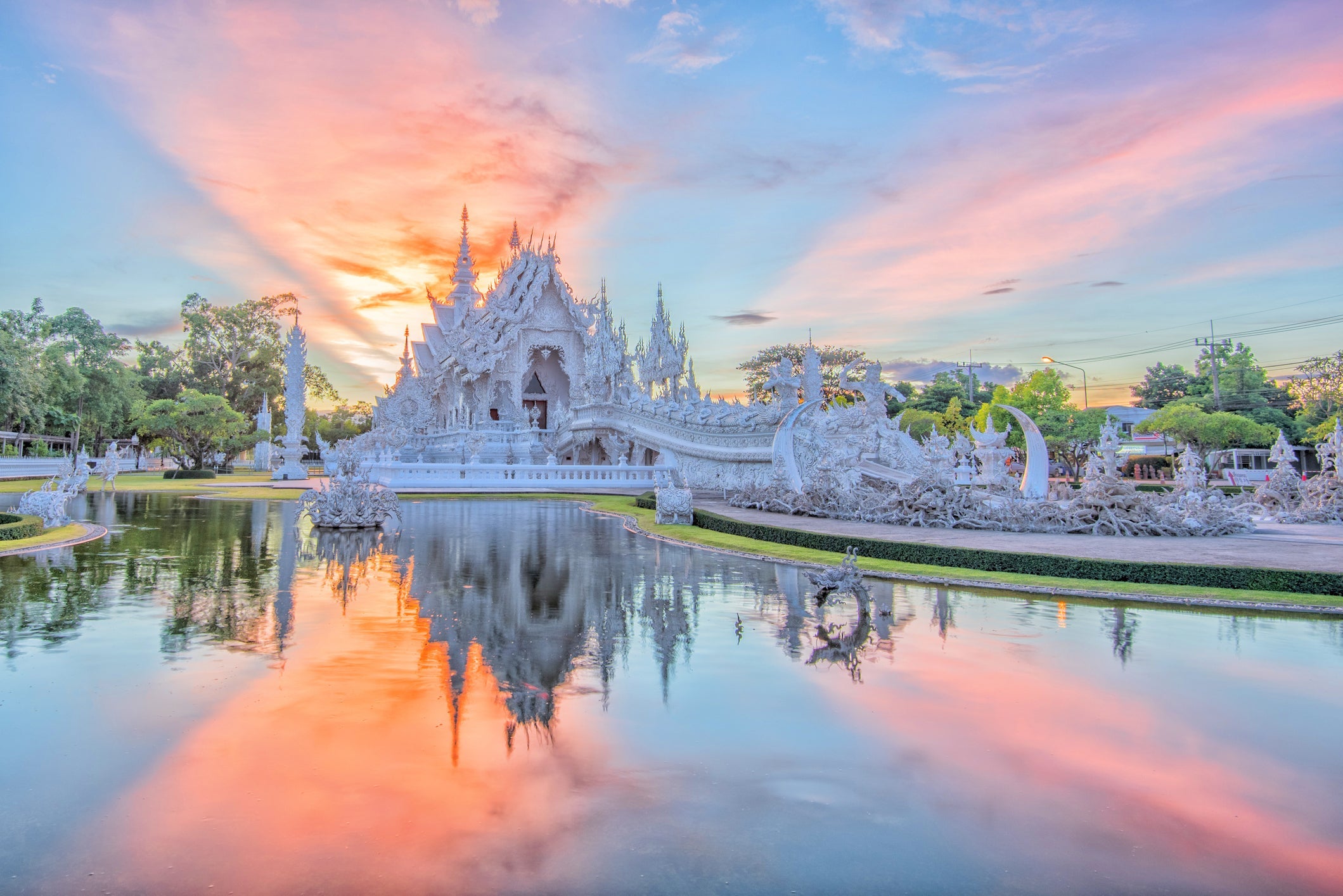 a white temple with a sunset behind it