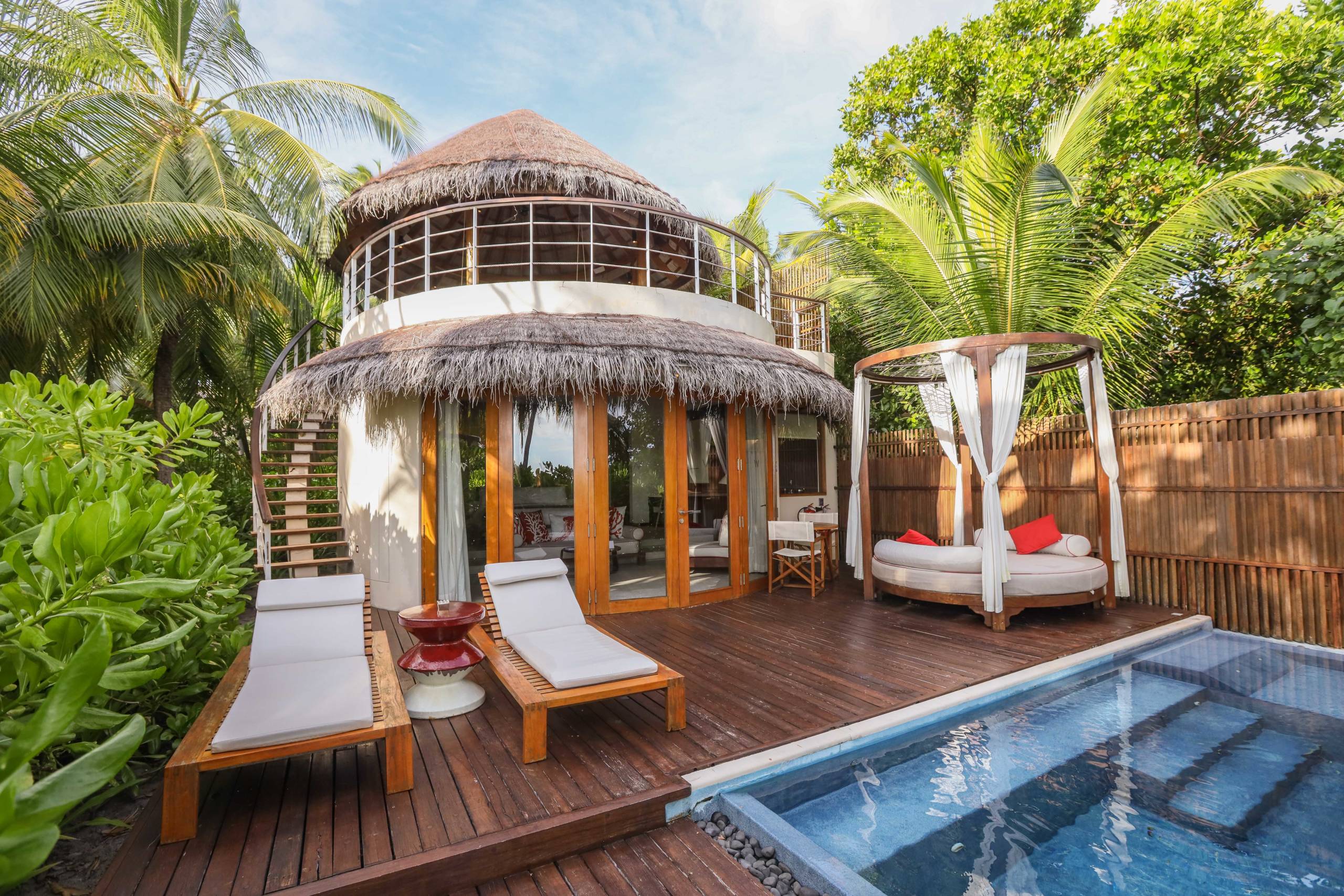 a beach hut-style hotel room with a small pool