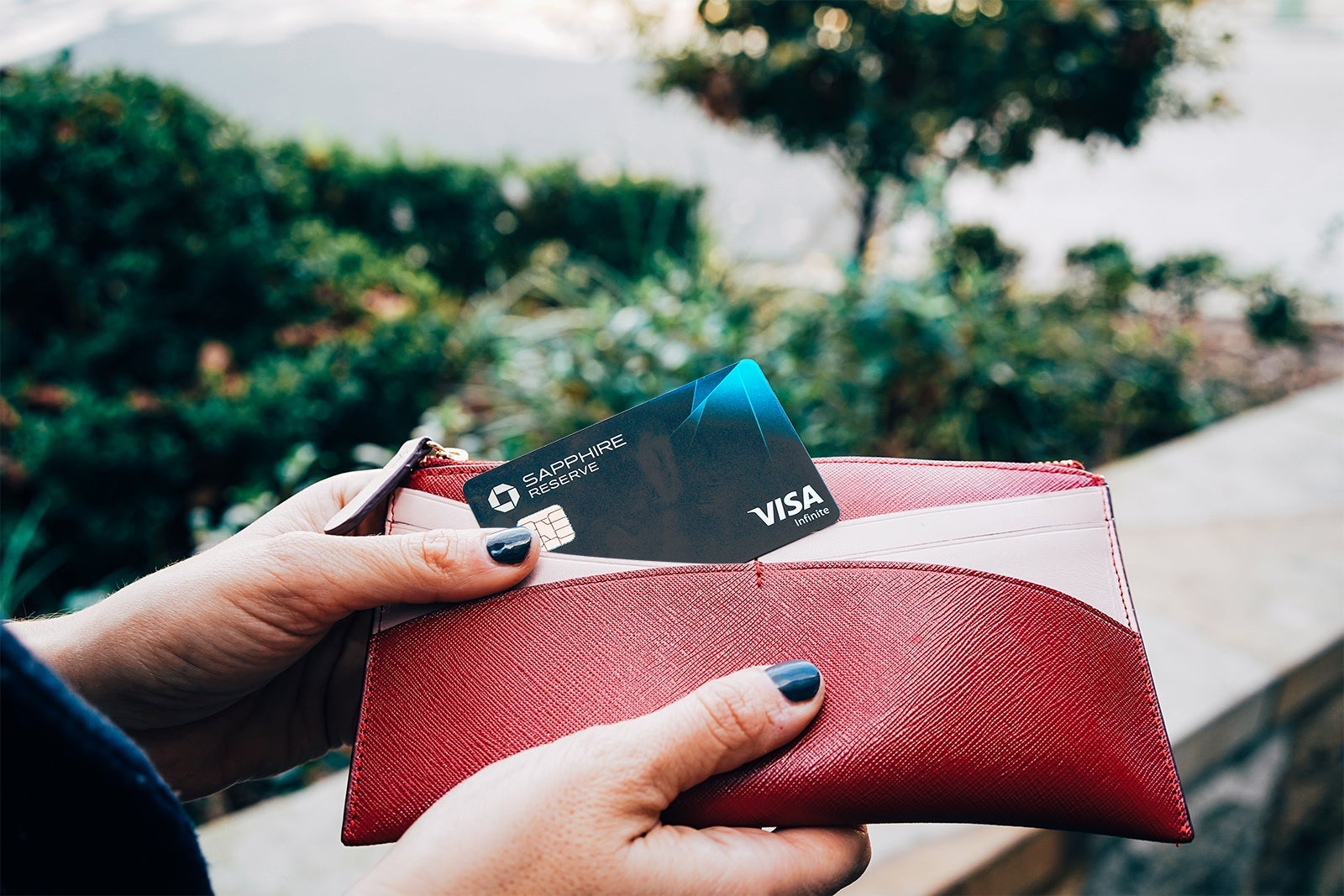 a hand pulls a credit card out of a wallet