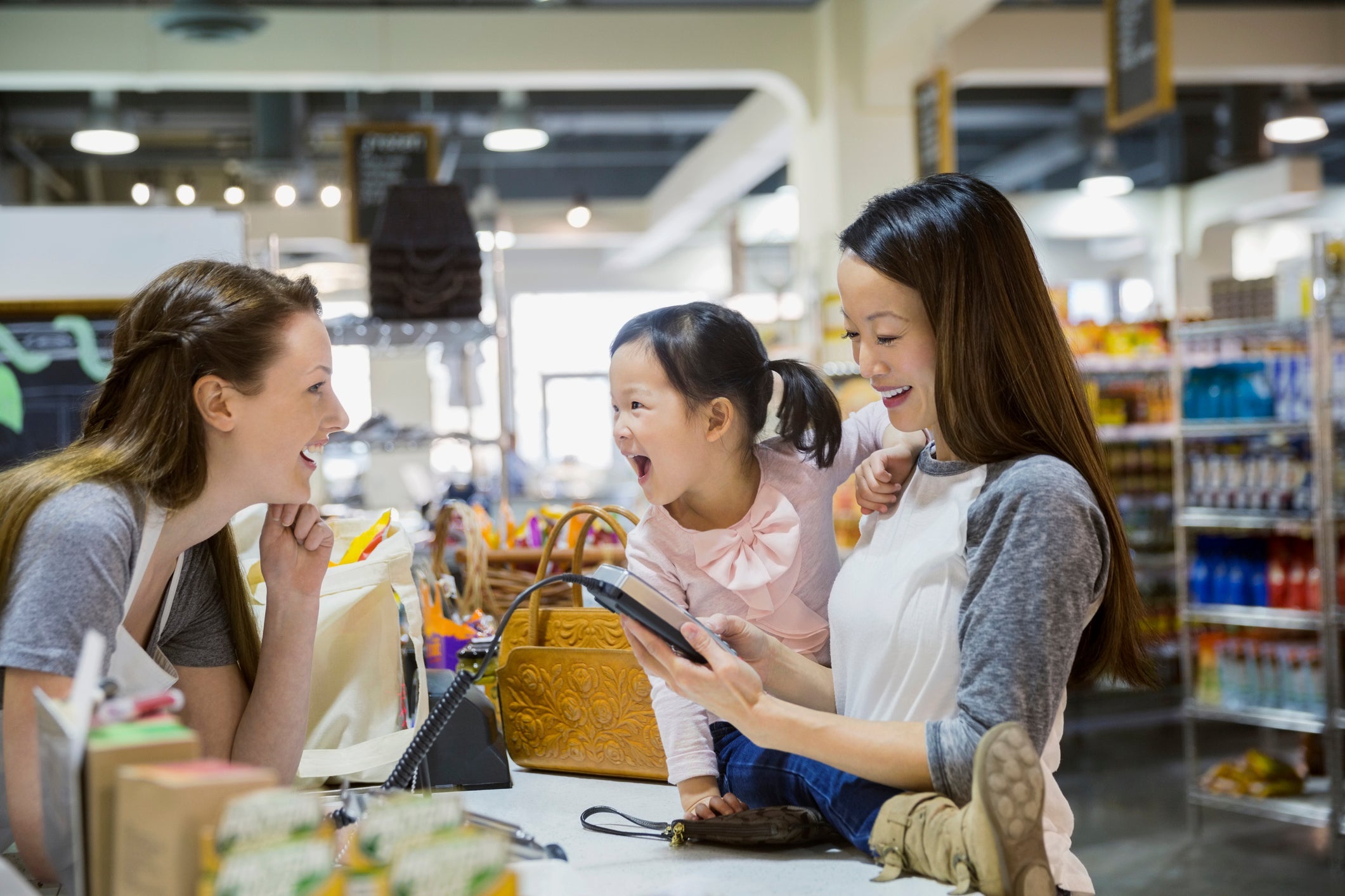 mother and child paying with credit card at store