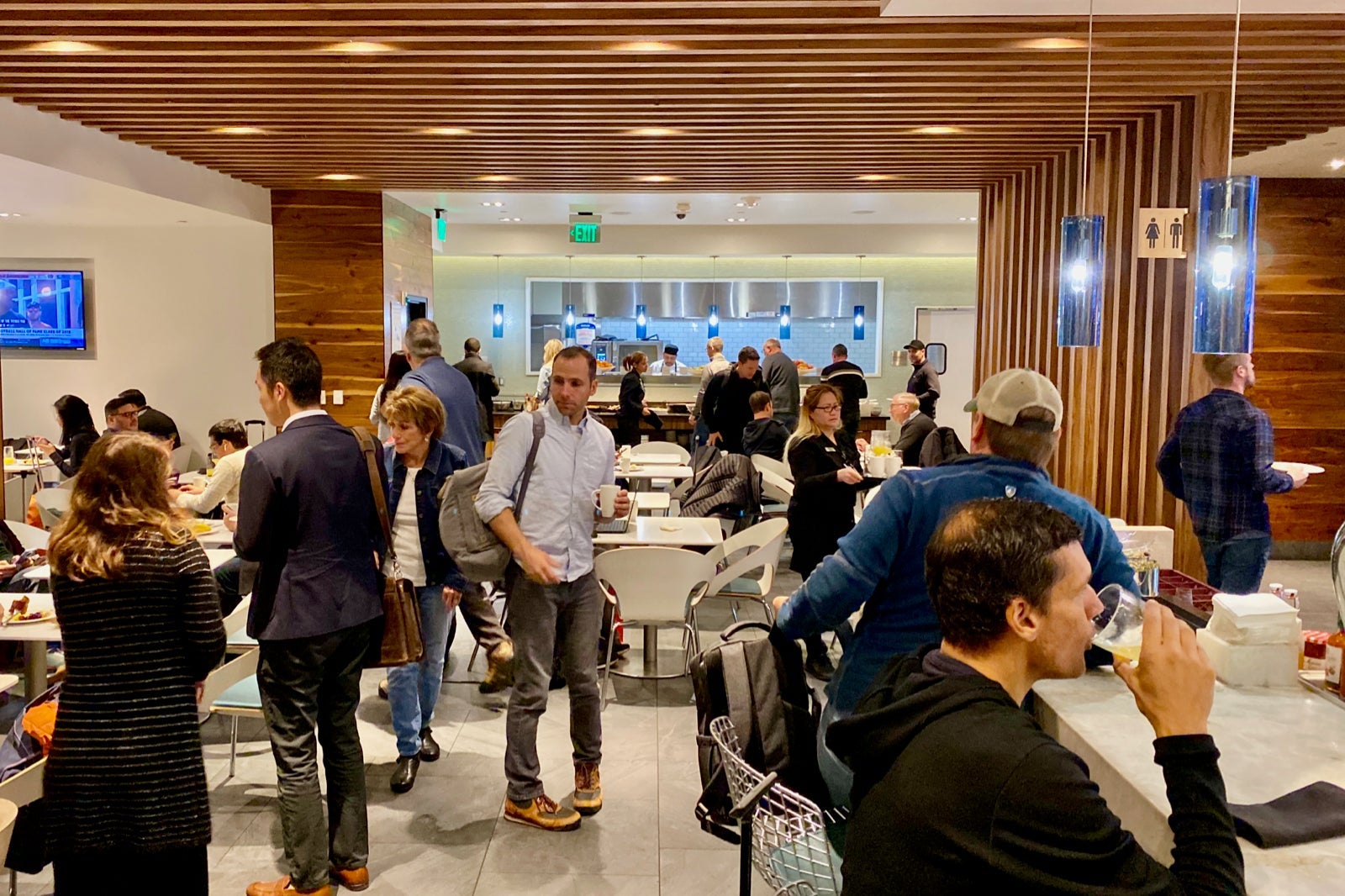 people look for seats in a crowded airport lounge