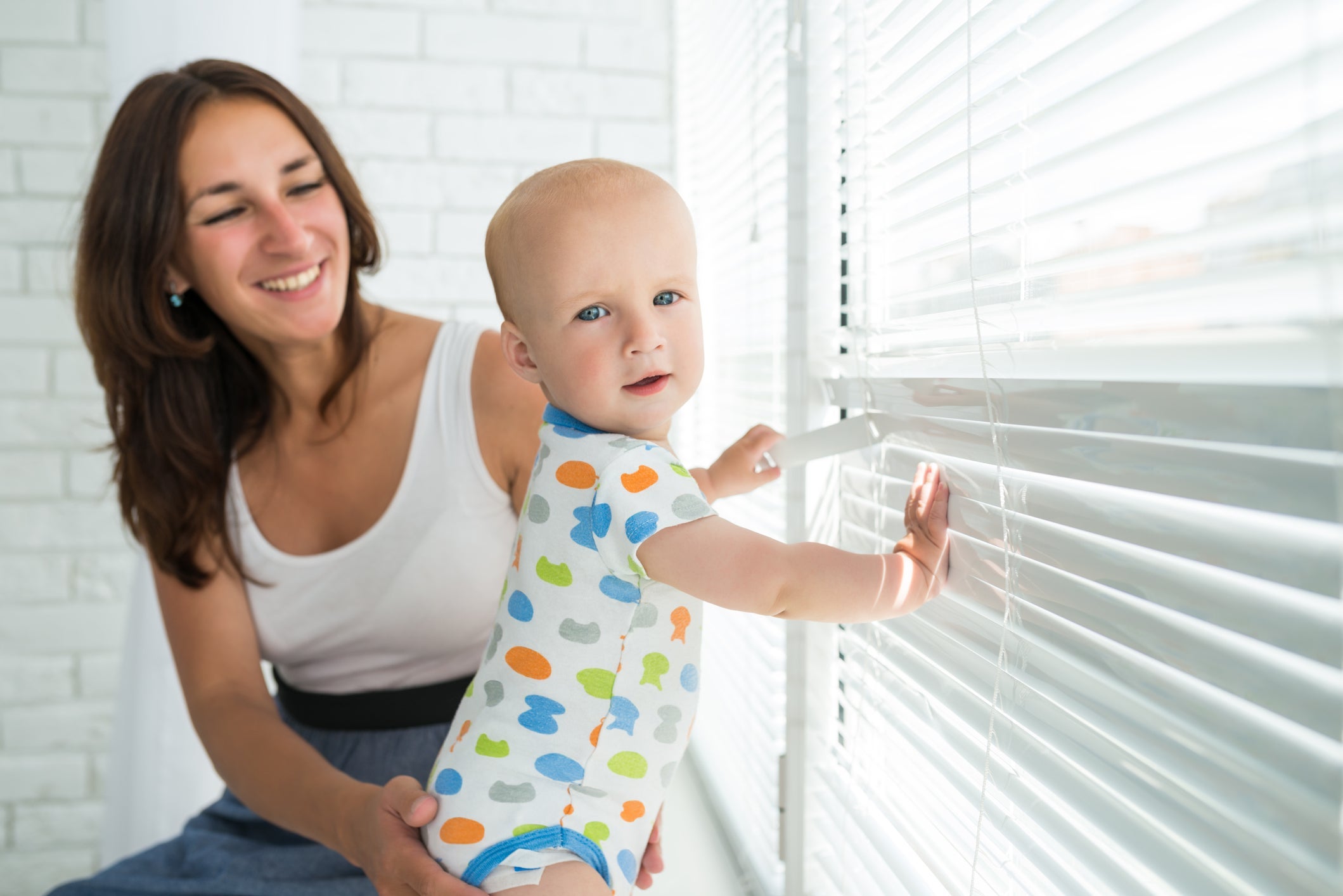 baby playing with bllinds