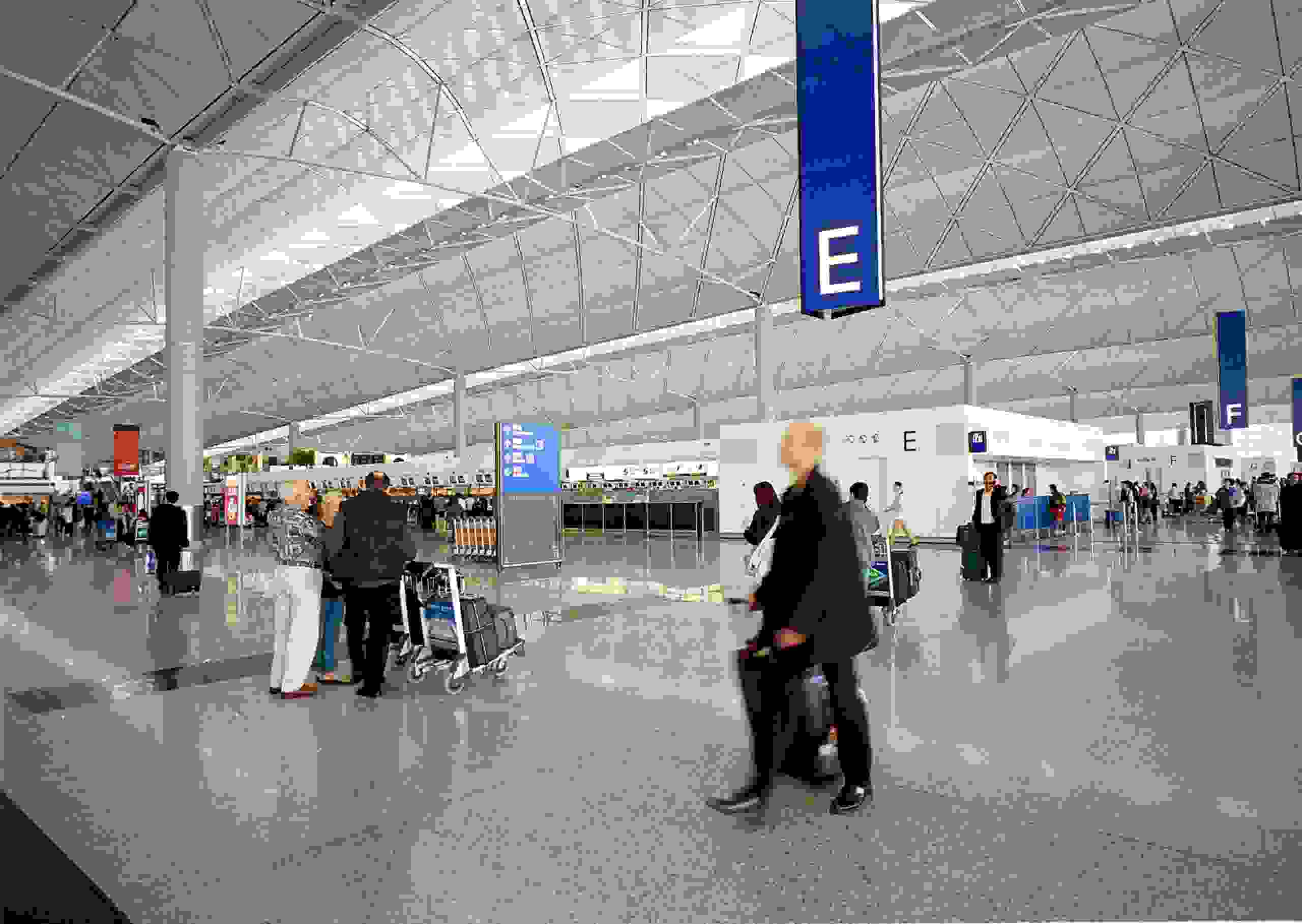 368314 04: A traveler walks in the departure hall at Chek Lap Kok Airport April 26, 2000 in Hong Kong. The world's largest covered public space was designed by British architect Sir Norman Foster. (Photo by Michel Porro/Newsmakers)
