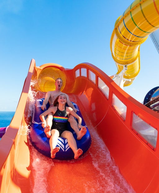 Two kids riding on cruise ship Navigator of the Seas' Blaster slide