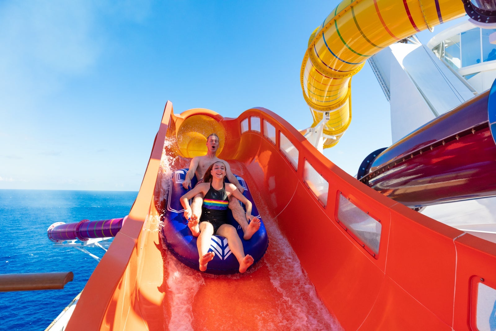 Two kids riding on cruise ship Navigator of the Seas' Blaster slide