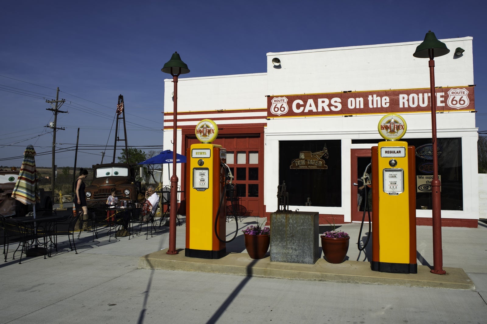old yellow gas pumps in front of a small white and red building
