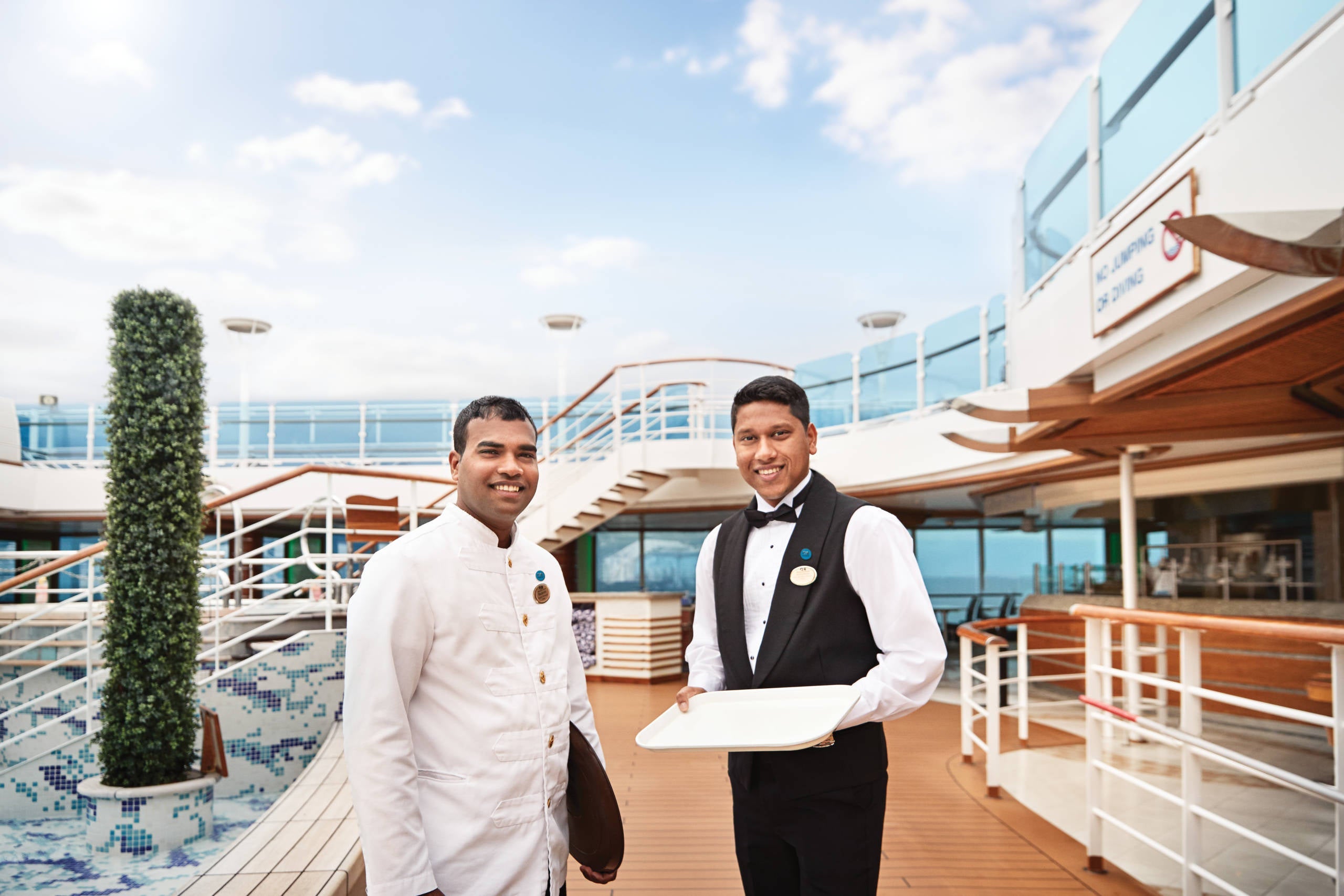 Waitstaff by pool on cruise ship deck