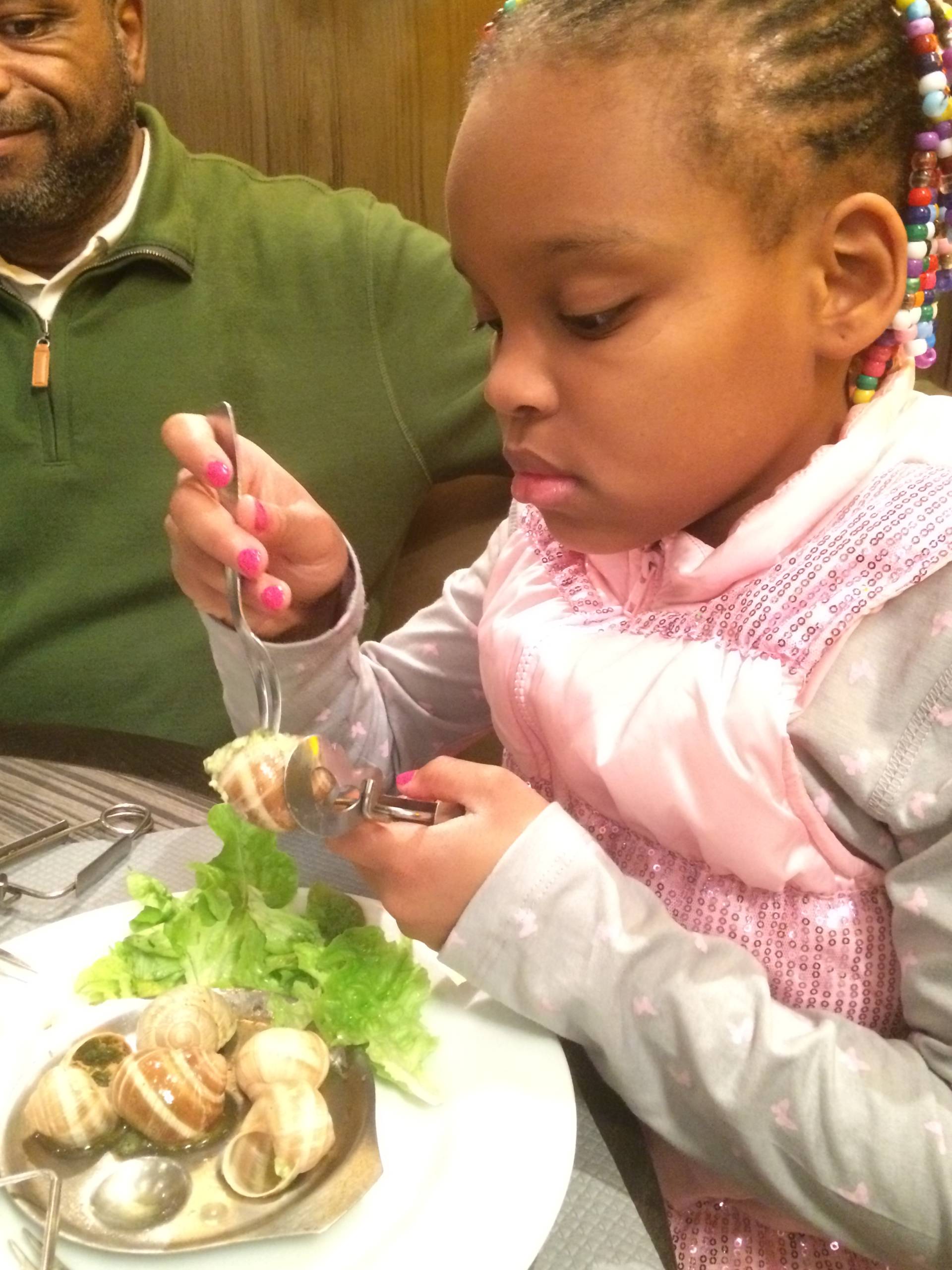 My daughter enjoying escargot during a Christmas trip to Paris. (Photo by Benét J. Wilson/The Points Guy)