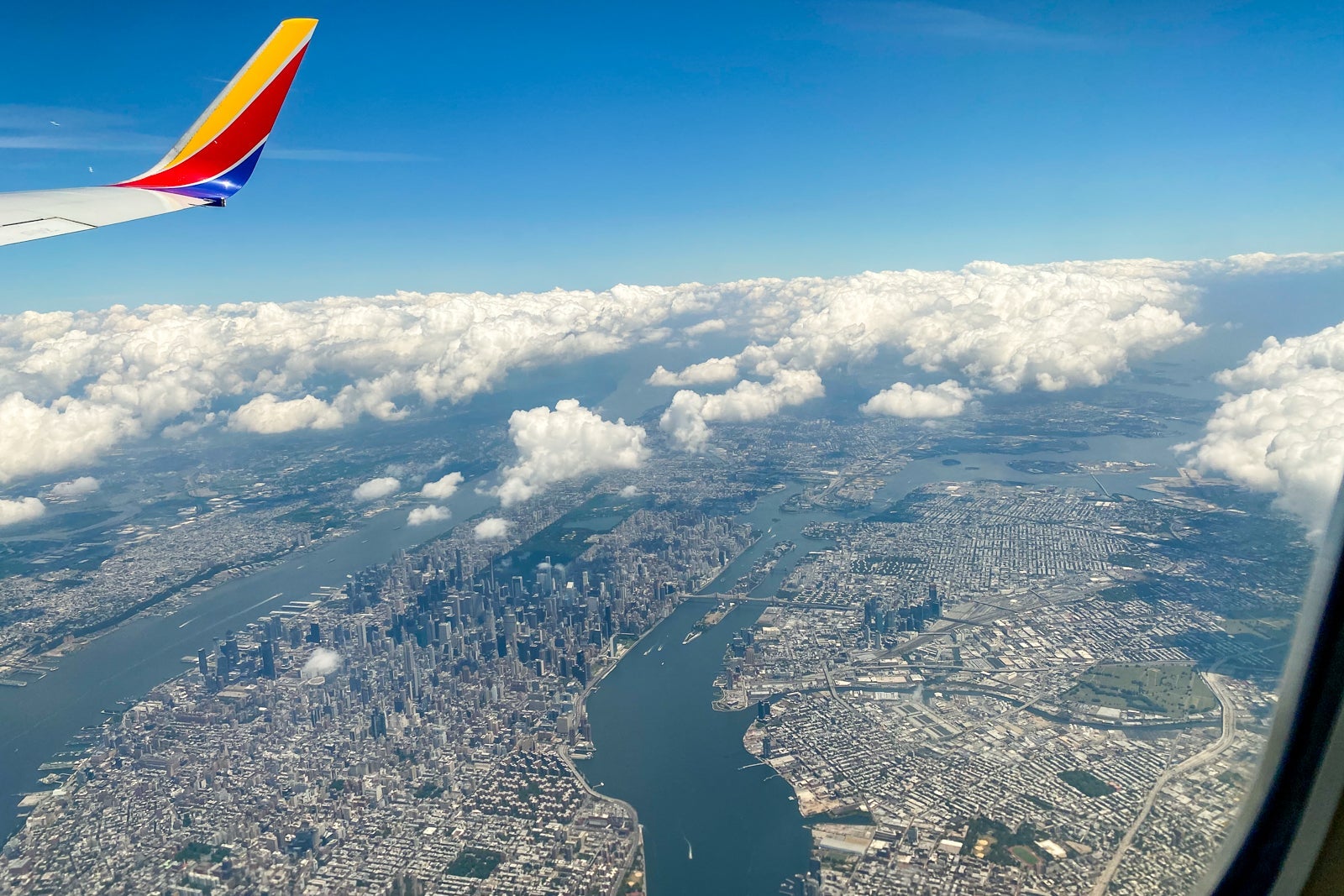 view of Southwest wingtip while flying over city
