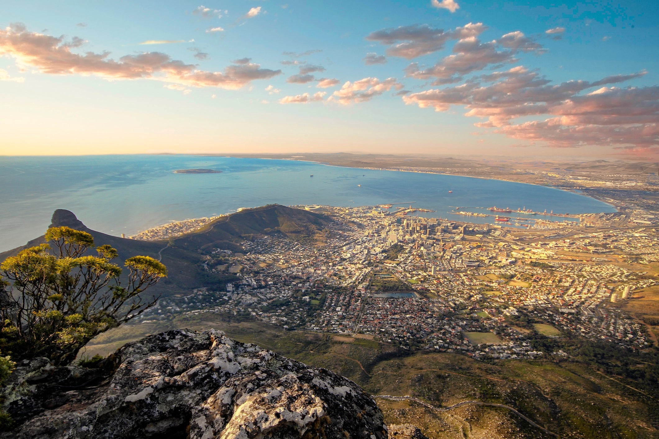 Beautiful sunset and landscape of Cape Town from Table Mountain lookout, this is the best sight in the city of Cape Town in South Africa, you can see everything in a clear day.This is a dramatic landscape of the area, we see some clouds and colorful sky, the sunlight is about to set and is casting some wonderful colors the city looks amazing.