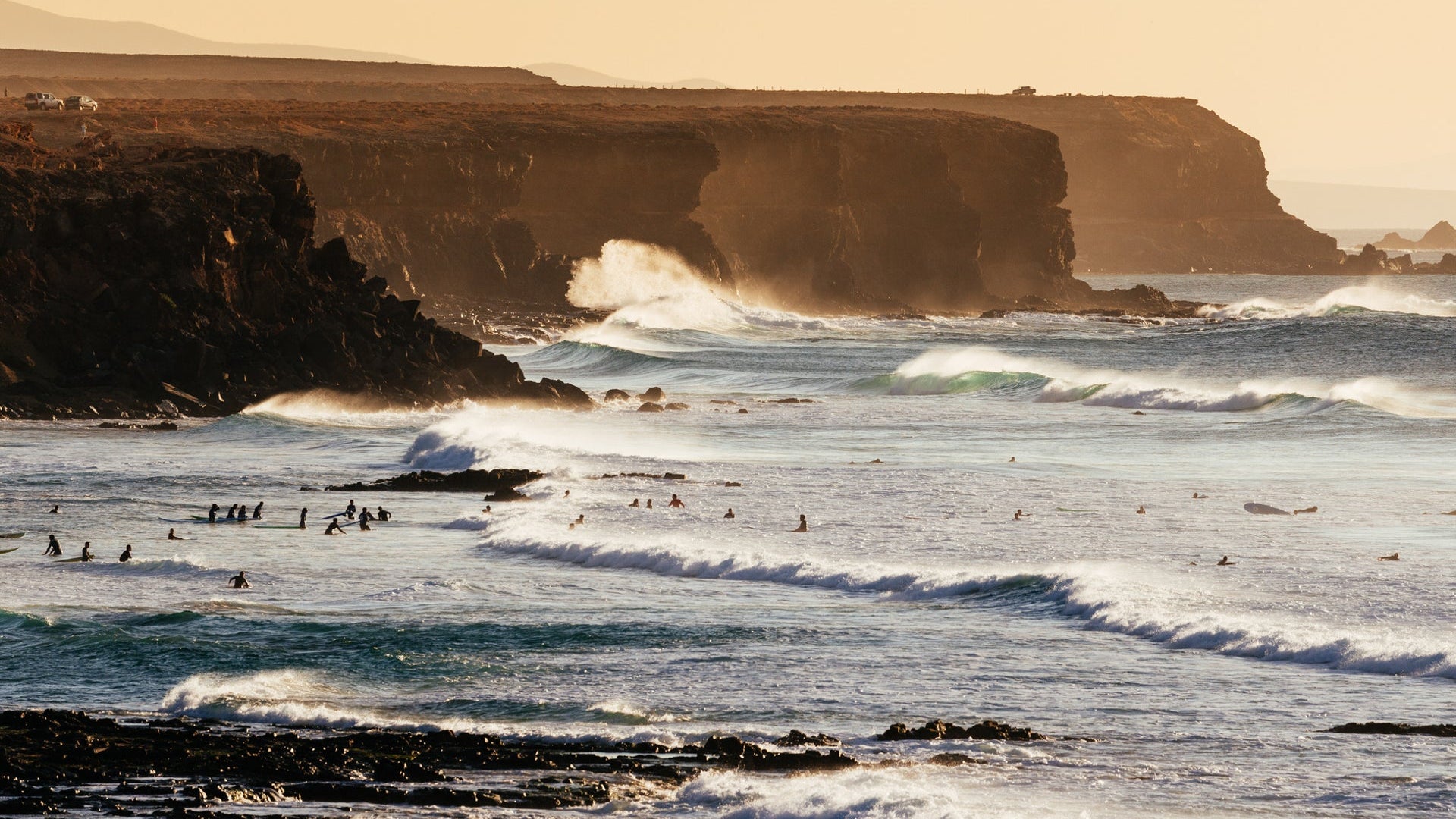 El Cotillo cliffs and beaches with waves and surfers at sunset, Fuerteventura