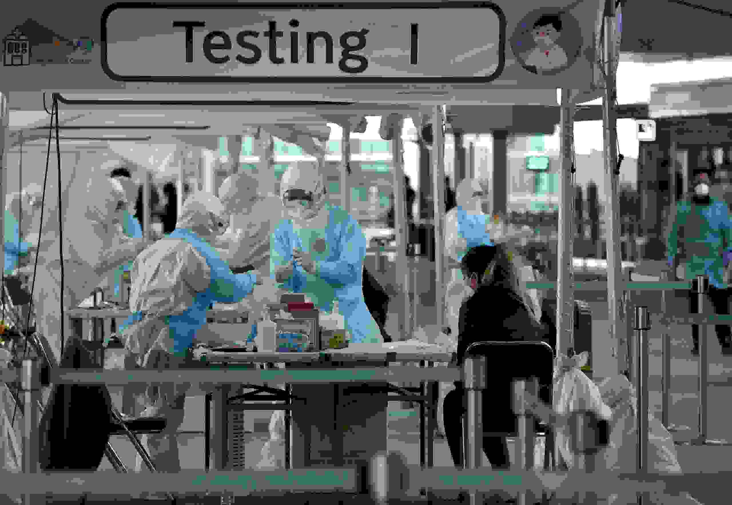 TOPSHOT - Medical staff wearing protective clothing take test samples for the COVID-19 coronavirus from a foreign passenger at a virus testing booth outside Incheon international airport, west of Seoul, on April 1, 2020. - The first charter flight arranged by South Korean government to evacuate its citizens from coronavirus-hit Italy returned home with 309 citizens on April 1, amid the worsening virus outbreak in the European country. (Photo by Jung Yeon-je / AFP) (Photo by JUNG YEON-JE/AFP via Getty Images)