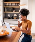 Young woman drinking coffee and checking the online shop