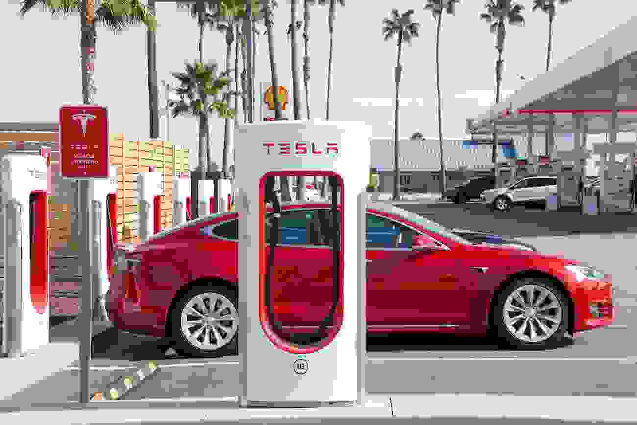 Red Tesla Charging at a Supercharger
