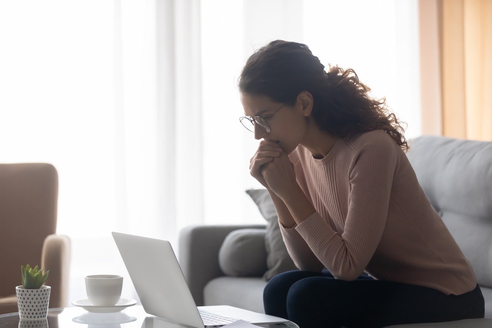 Woman looking pensively at laptop