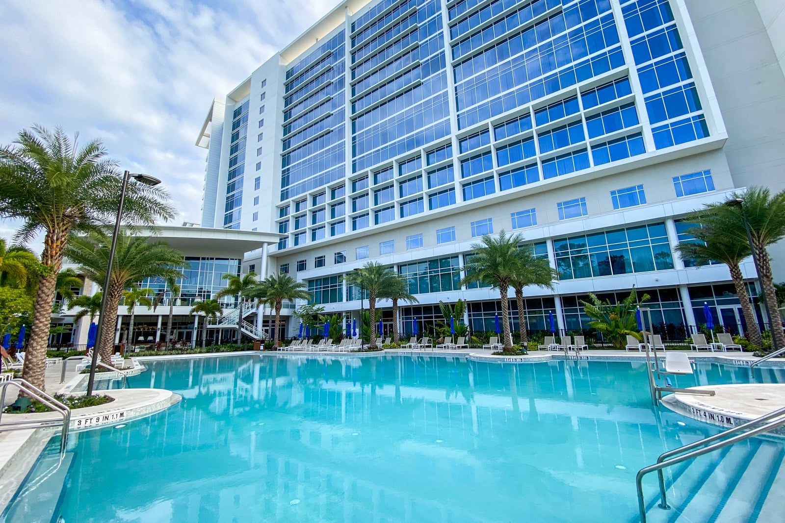 a hotel tower rises behind a pool
