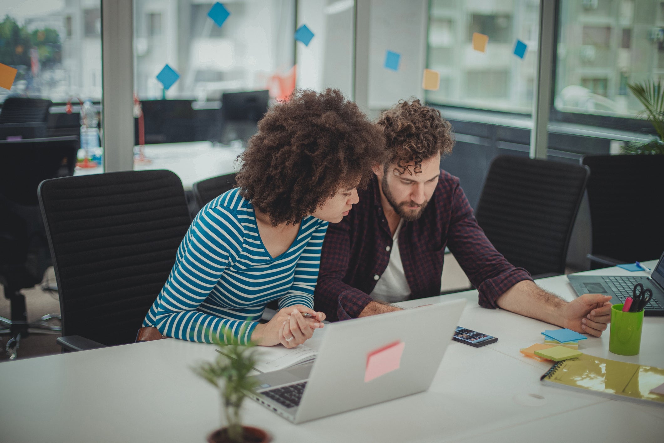 Two coworkers collaborate in an office environment