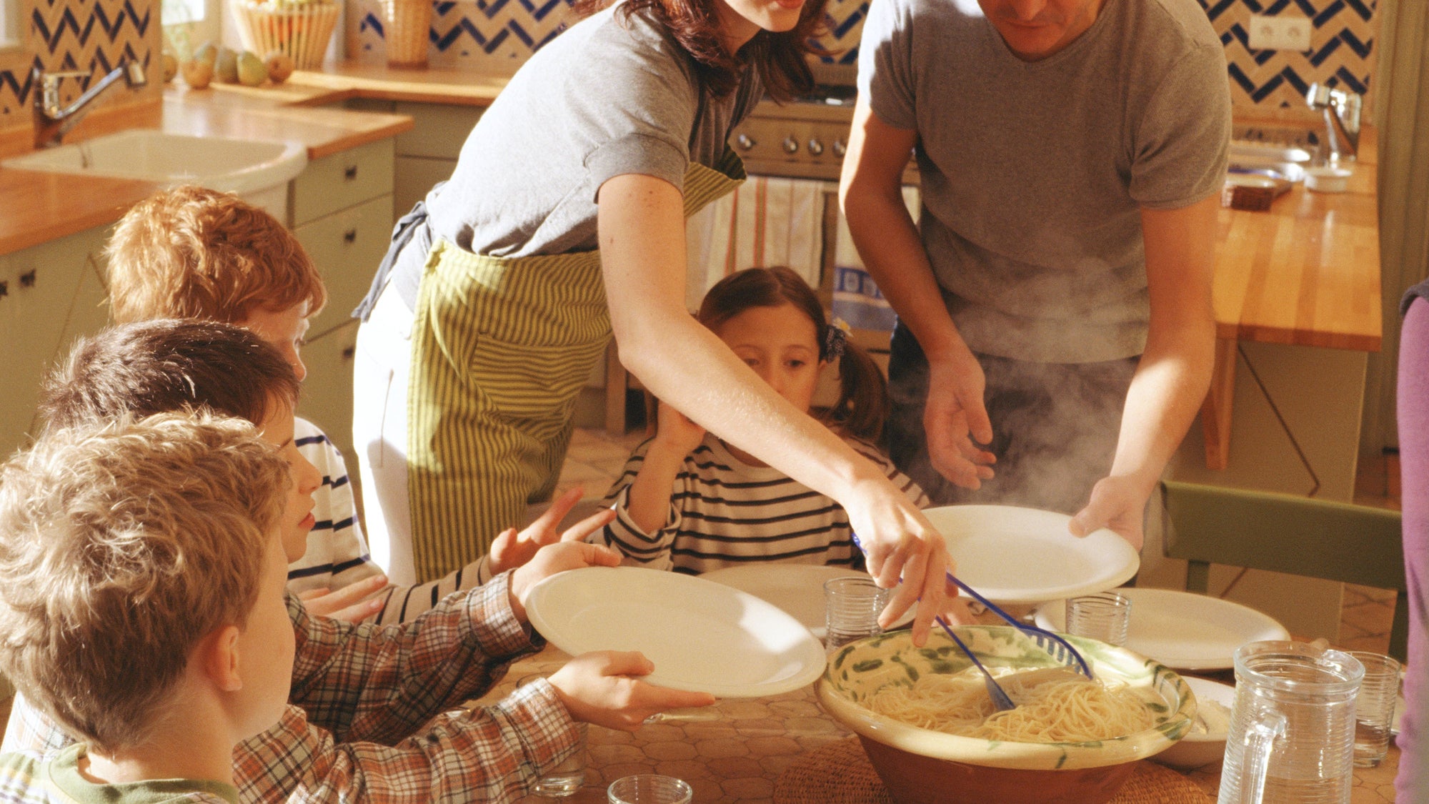 Man and woman serving children at table