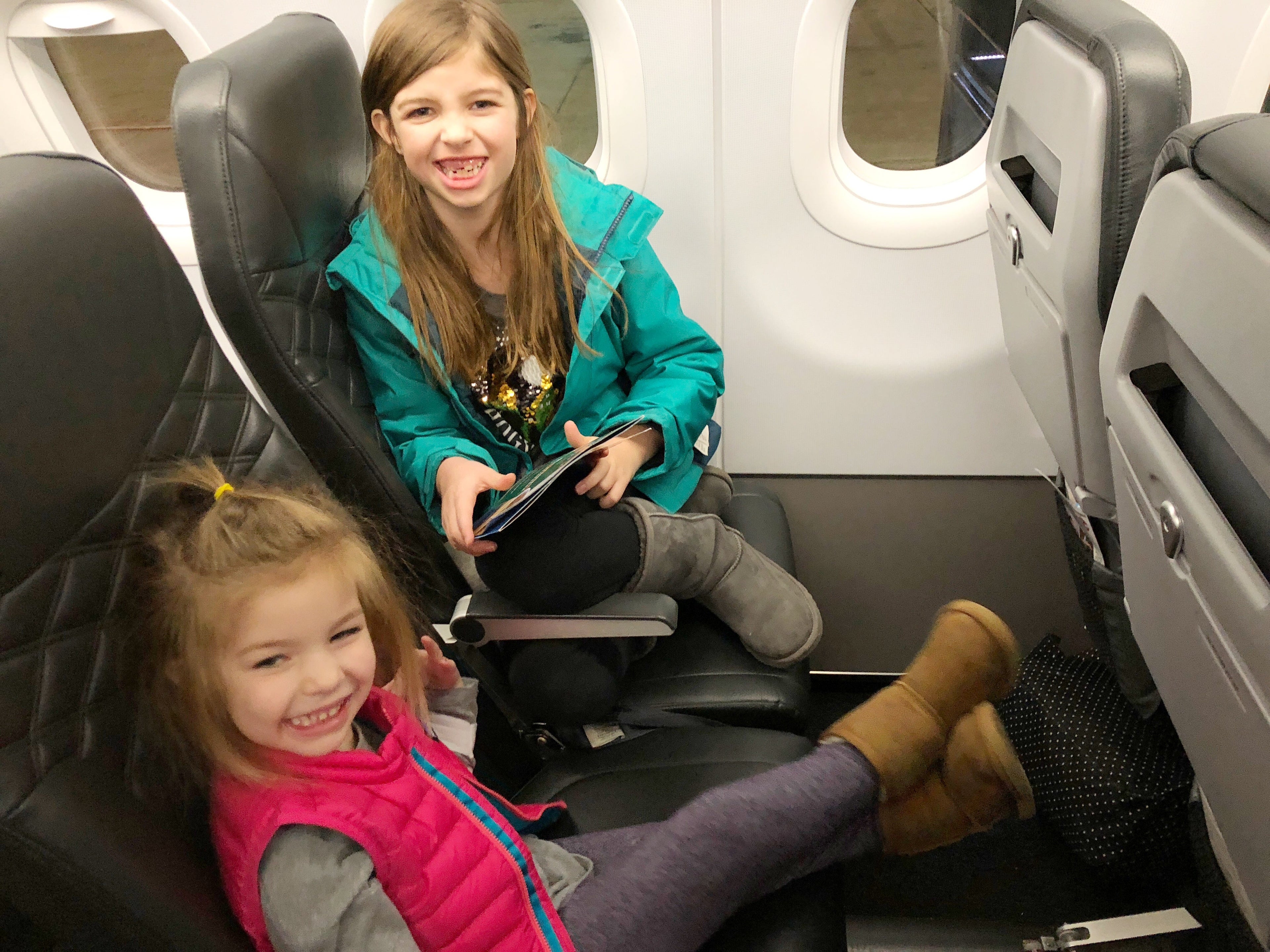 My girls enjoying extra legroom seats on Frontier Airlines