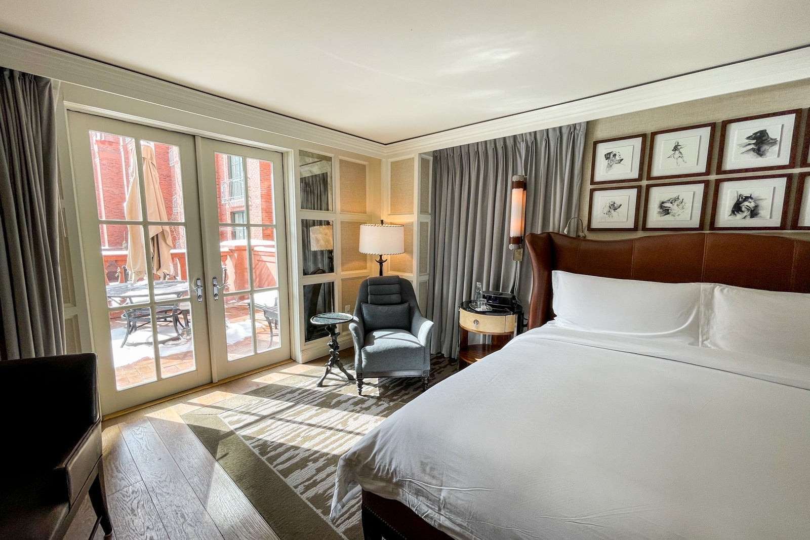a hotel bedroom with French doors leading to a snow-covered patio