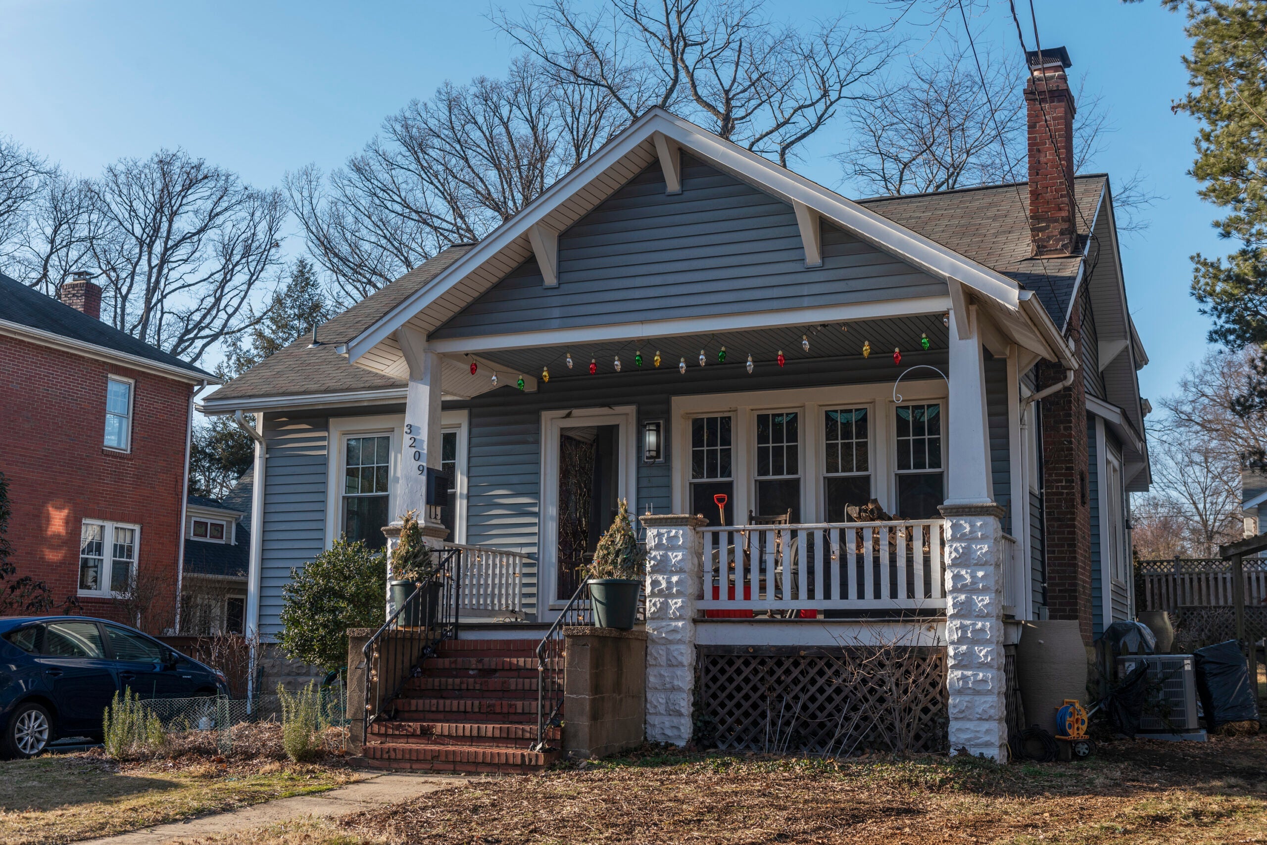 a light blue-colored house on a suburban street