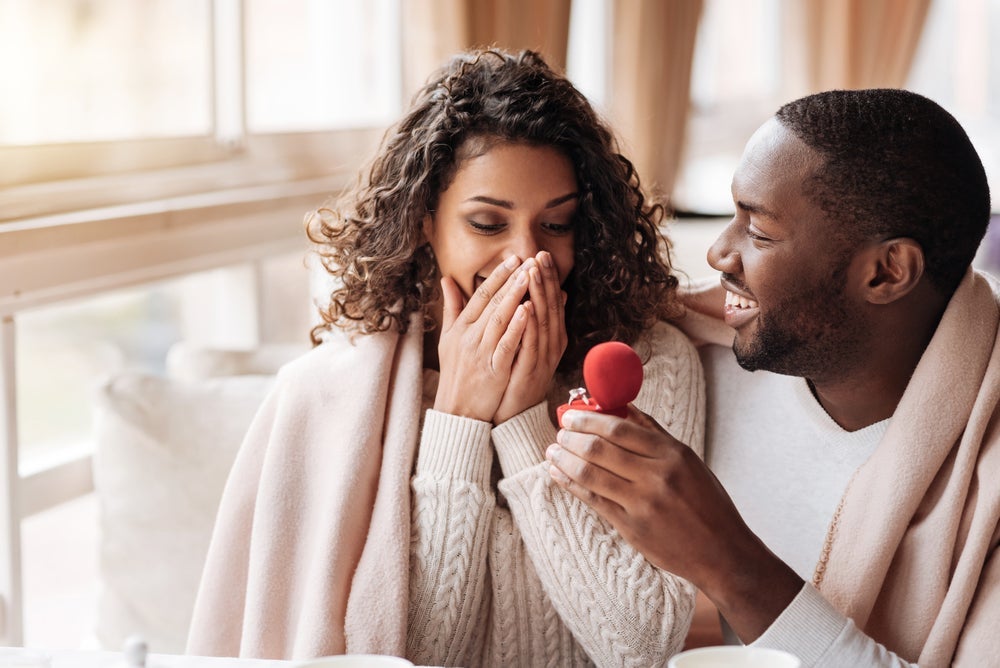 man proposing to woman at cafe