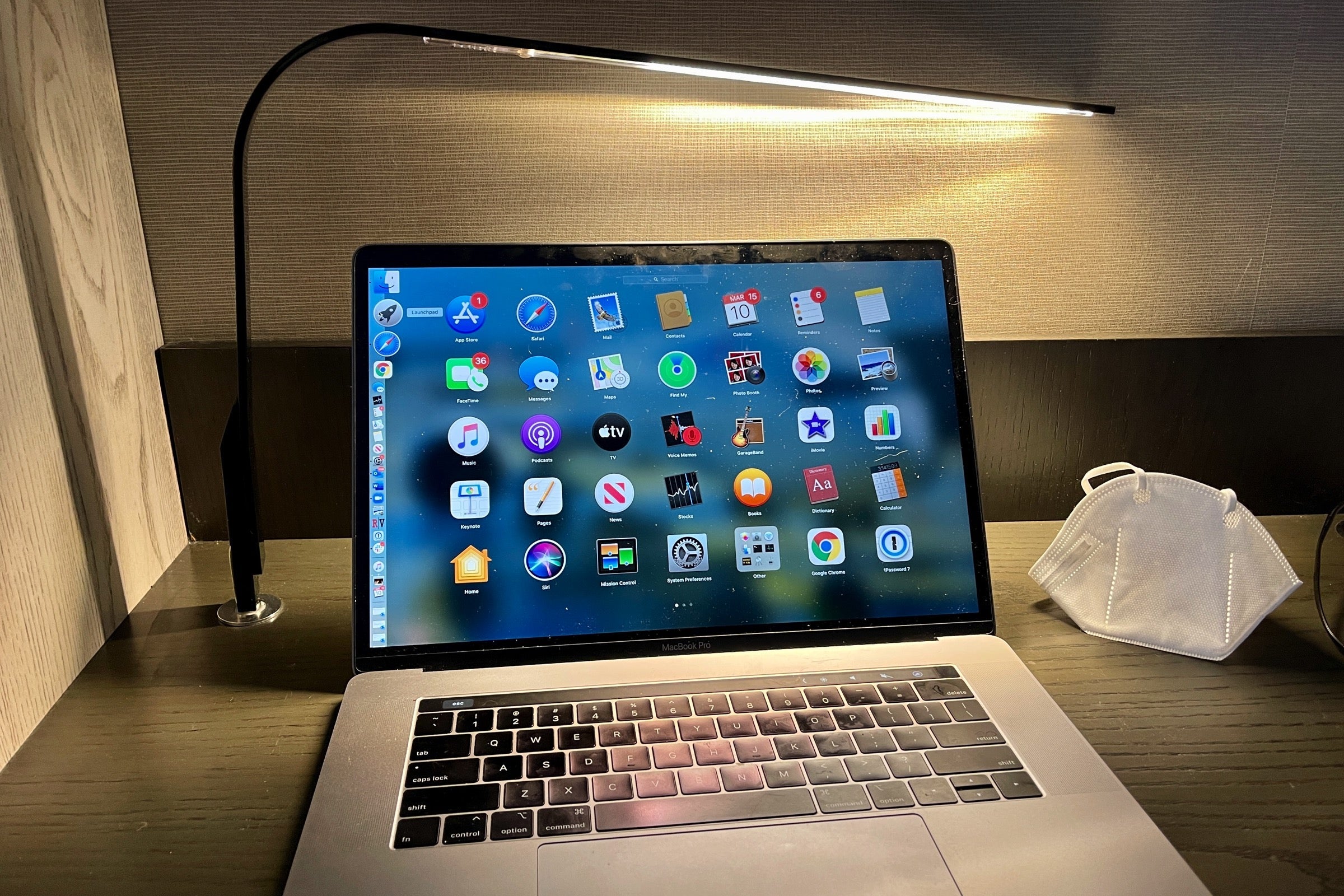 MacBook Pro on a desk next to a mask